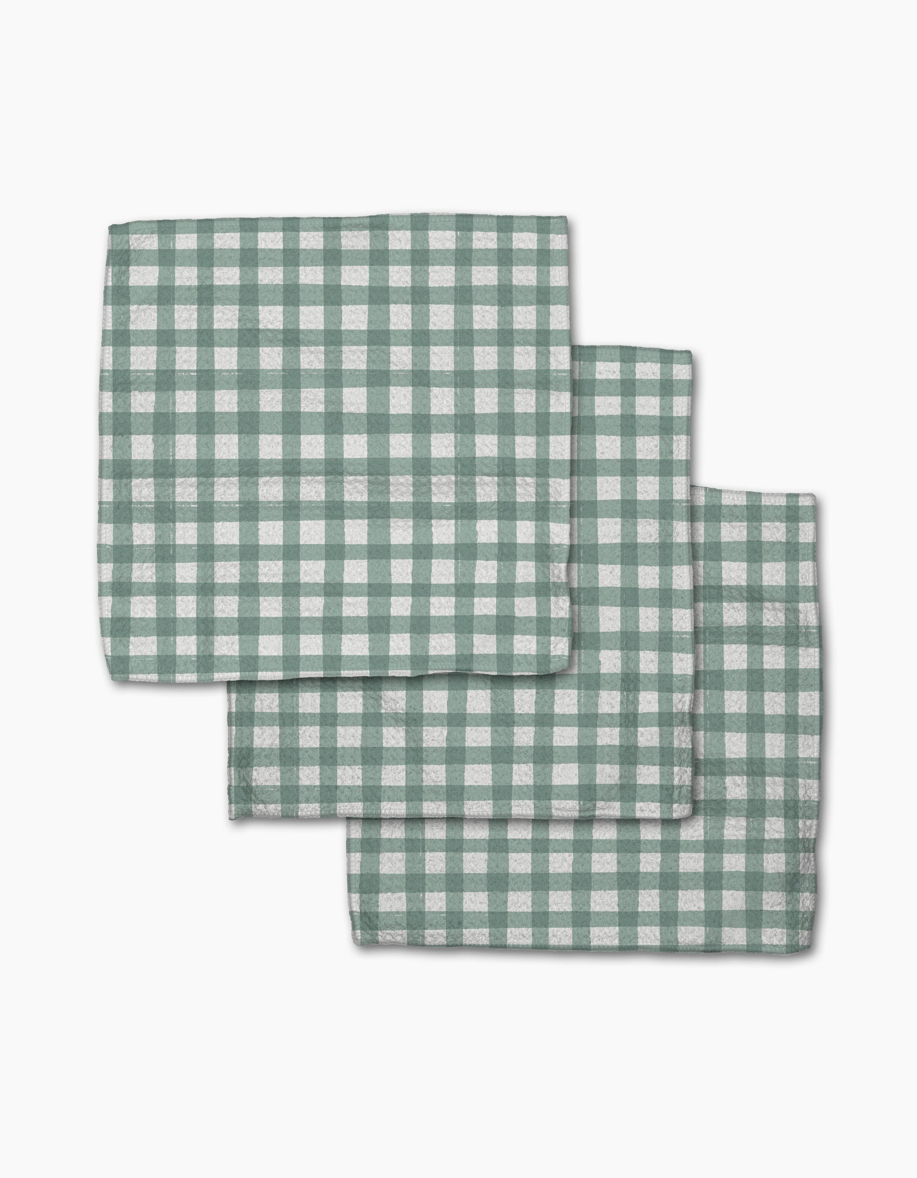 Three Picnic Gingham napkins from Hufton Studio, featuring a green and white check pattern, are neatly stacked with slight overlap on a white background.