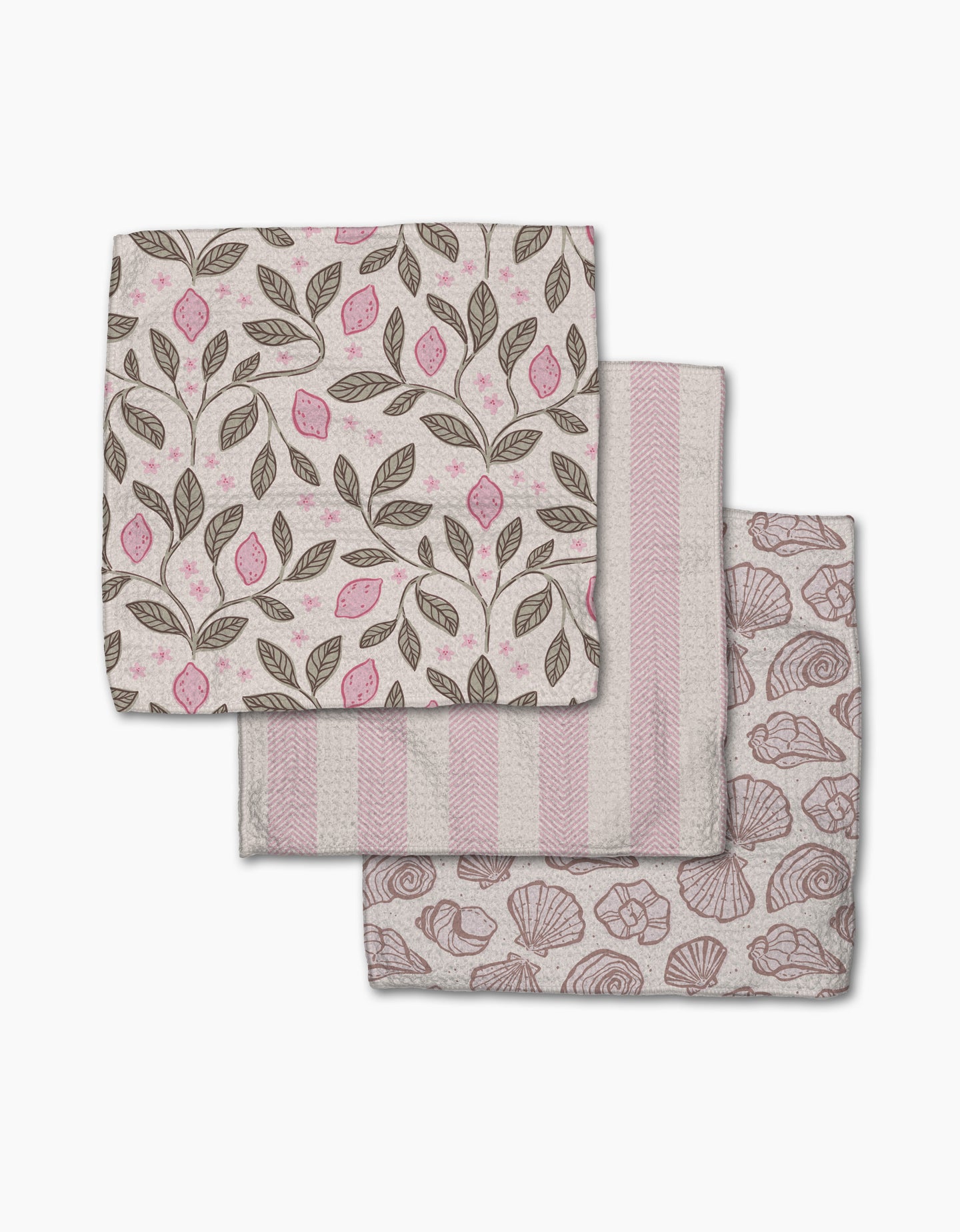 Three folded Pink Summer cloth napkins by Teri the Butter—one with pink and brown leaf and lemon print, one with pink and white stripes, and one with a pink seashell design—are arranged on a white background.