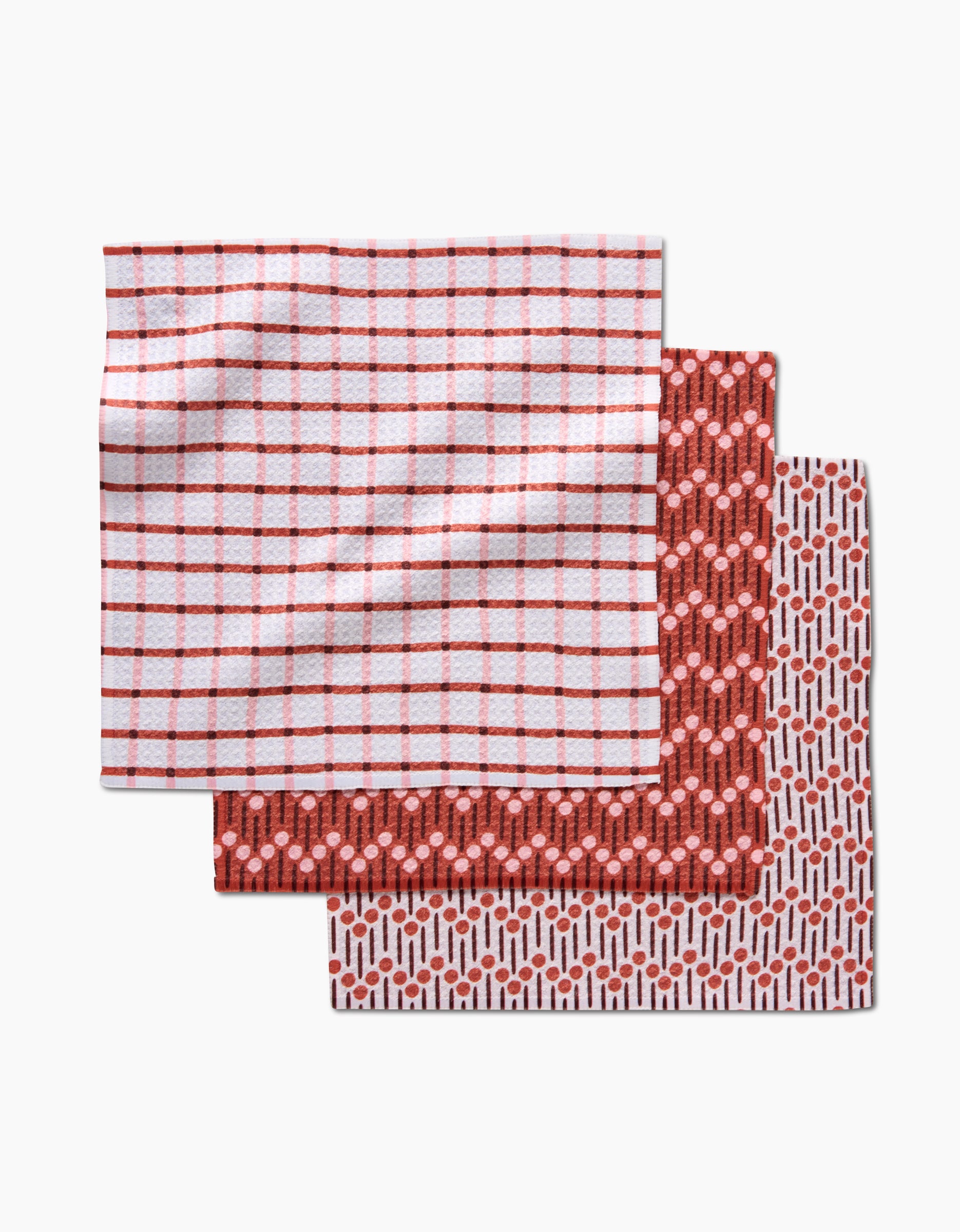 The Playful Retro dishcloth set by Teri the Butter features three recycled cloths in red and white: a red grid pattern, a geometric hexagon design, and a dotted motif on white.