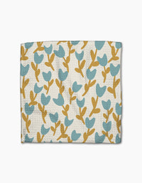 Introducing Polka Dot Blooms by Lizzie Clark—a wallet with a textured surface, adorned with blue tulip-inspired flowers and mustard stems on white, capturing the whimsical charm of super-absorbent recycled dishcloths.