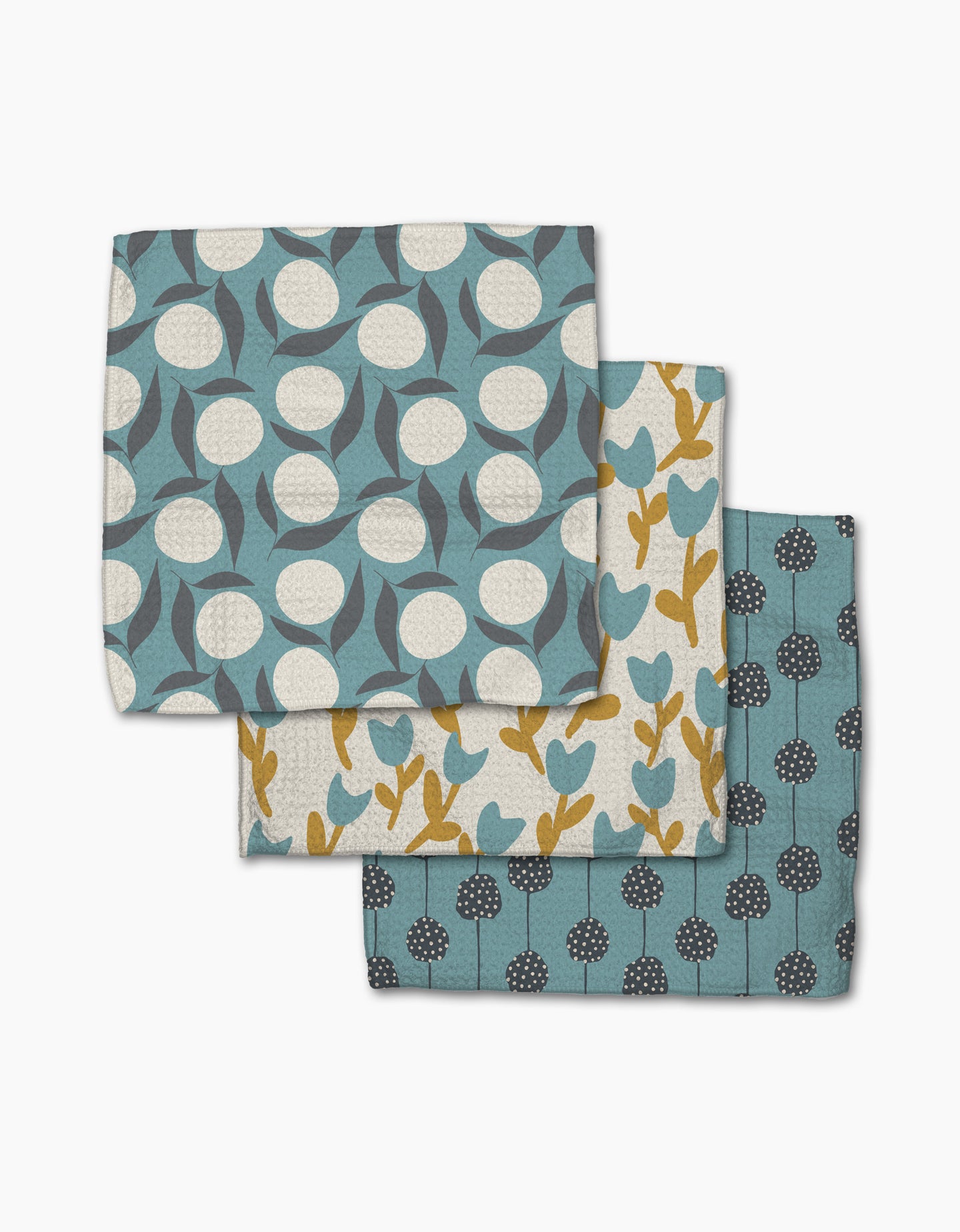 Polka Dot Blooms by Lizzie Clark includes three folded tea towels made from recycled materials, each featuring unique botanical patterns in blue, yellow, and white.