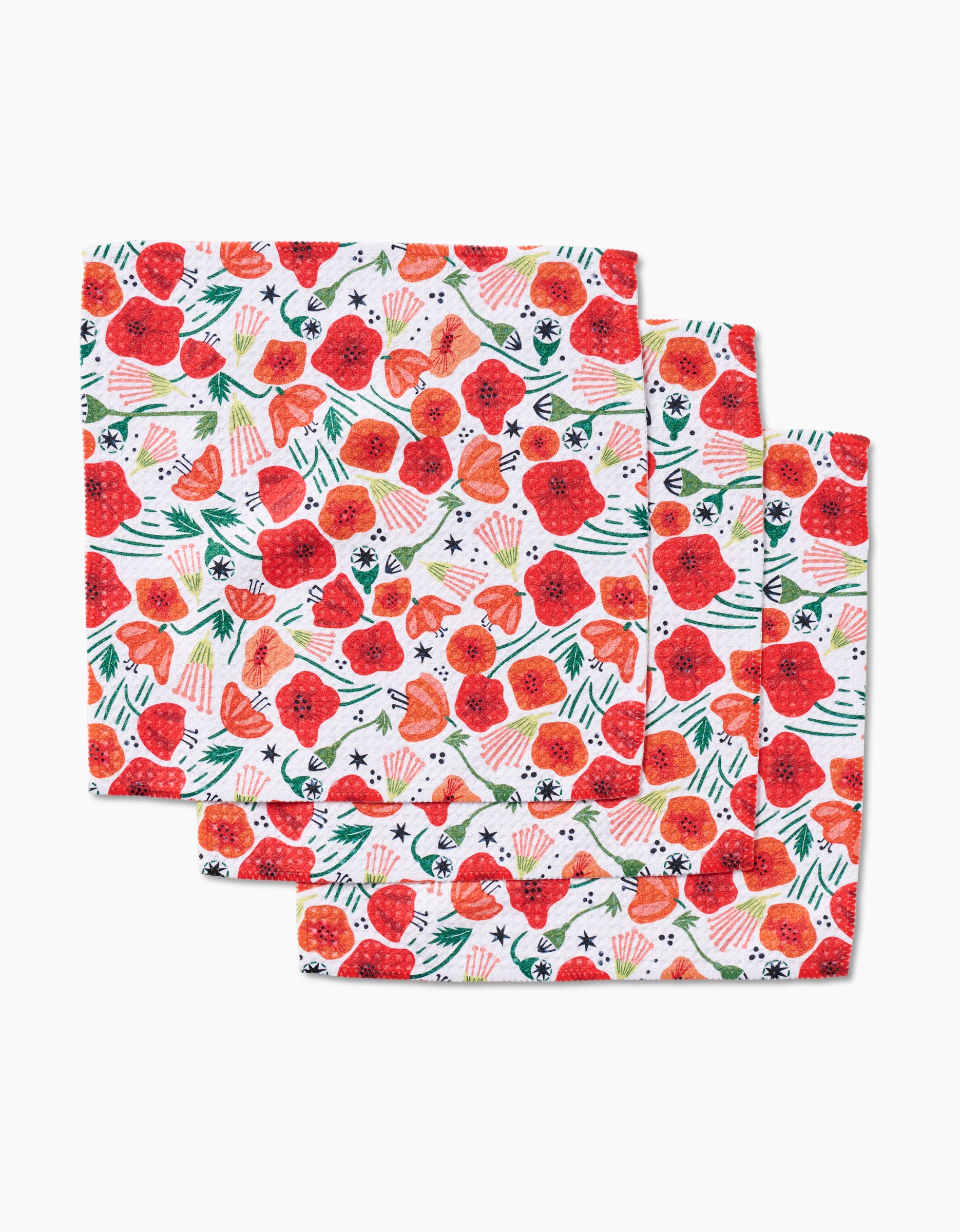 Four Poppy Power cloth napkins by Elisabeth Wing, made of soft geoweave fabric with a vibrant red-orange floral and green leaf pattern, are stacked in a slightly overlapping arrangement on a white background.
