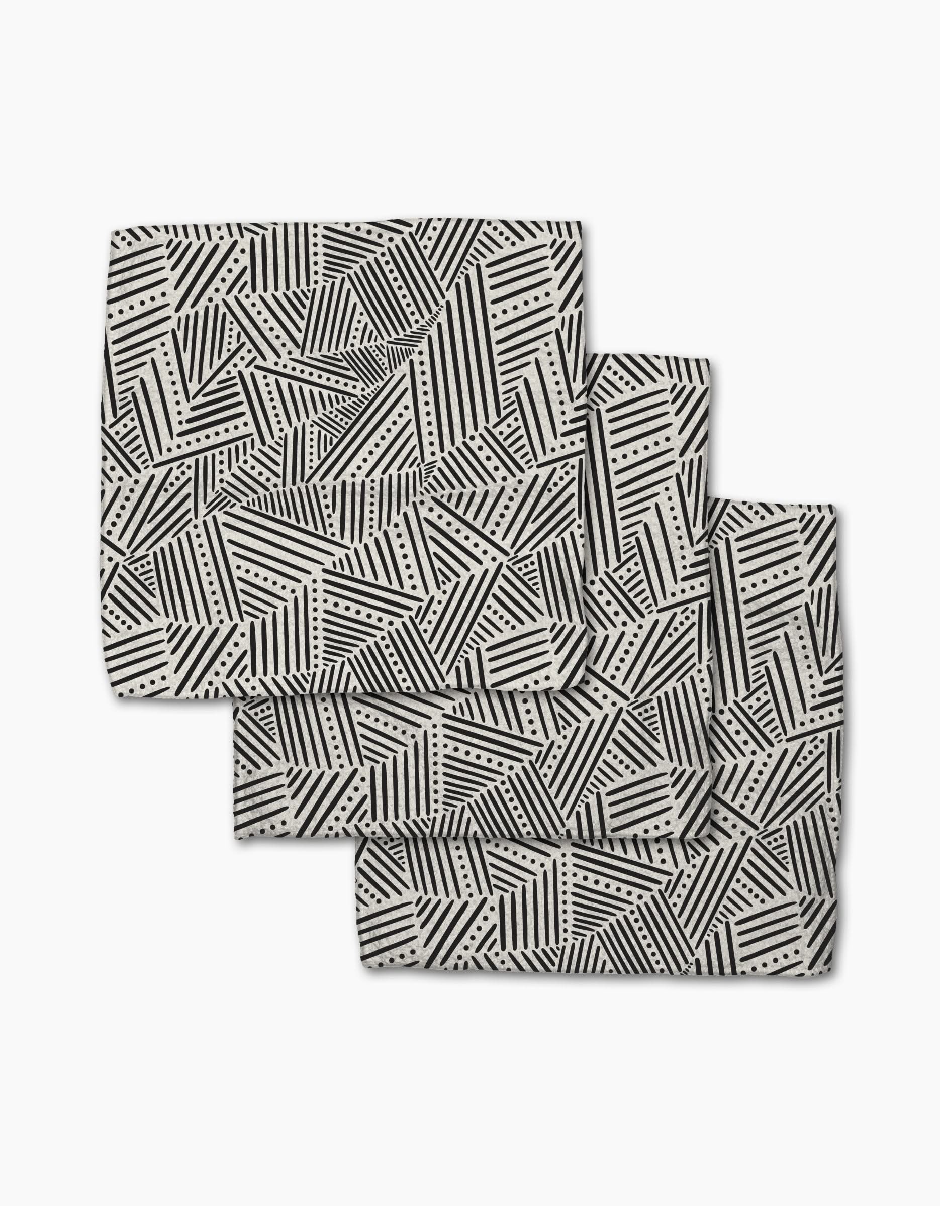 The Rhythm Current Stripes dishcloth set by Sarah Daugherty features three folded rectangular napkins with a black and white geometric pattern, made from recycled materials for a chic, eco-friendly addition to your home.