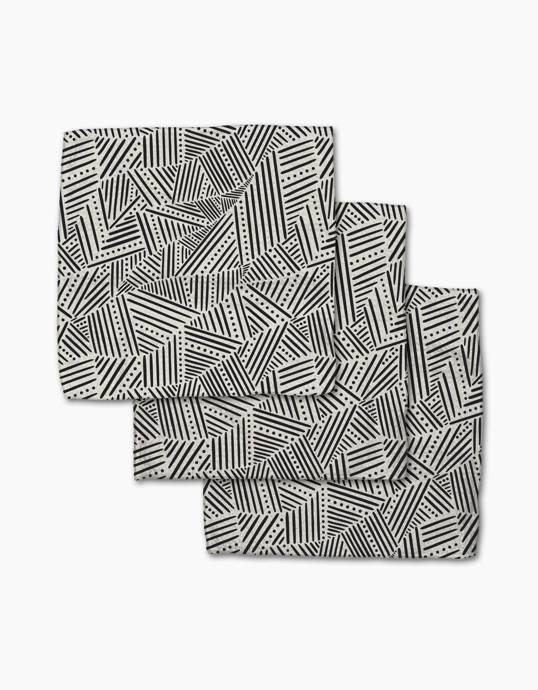 The Rhythm Current Stripes dishcloth set by Sarah Daugherty features three folded rectangular napkins with a black and white geometric pattern, made from recycled materials for a chic, eco-friendly addition to your home.