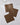 Three Ridge napkins by Geometry, made from recycled materials, feature a black geometric pattern on brown fabric and are arranged on a white marble surface.