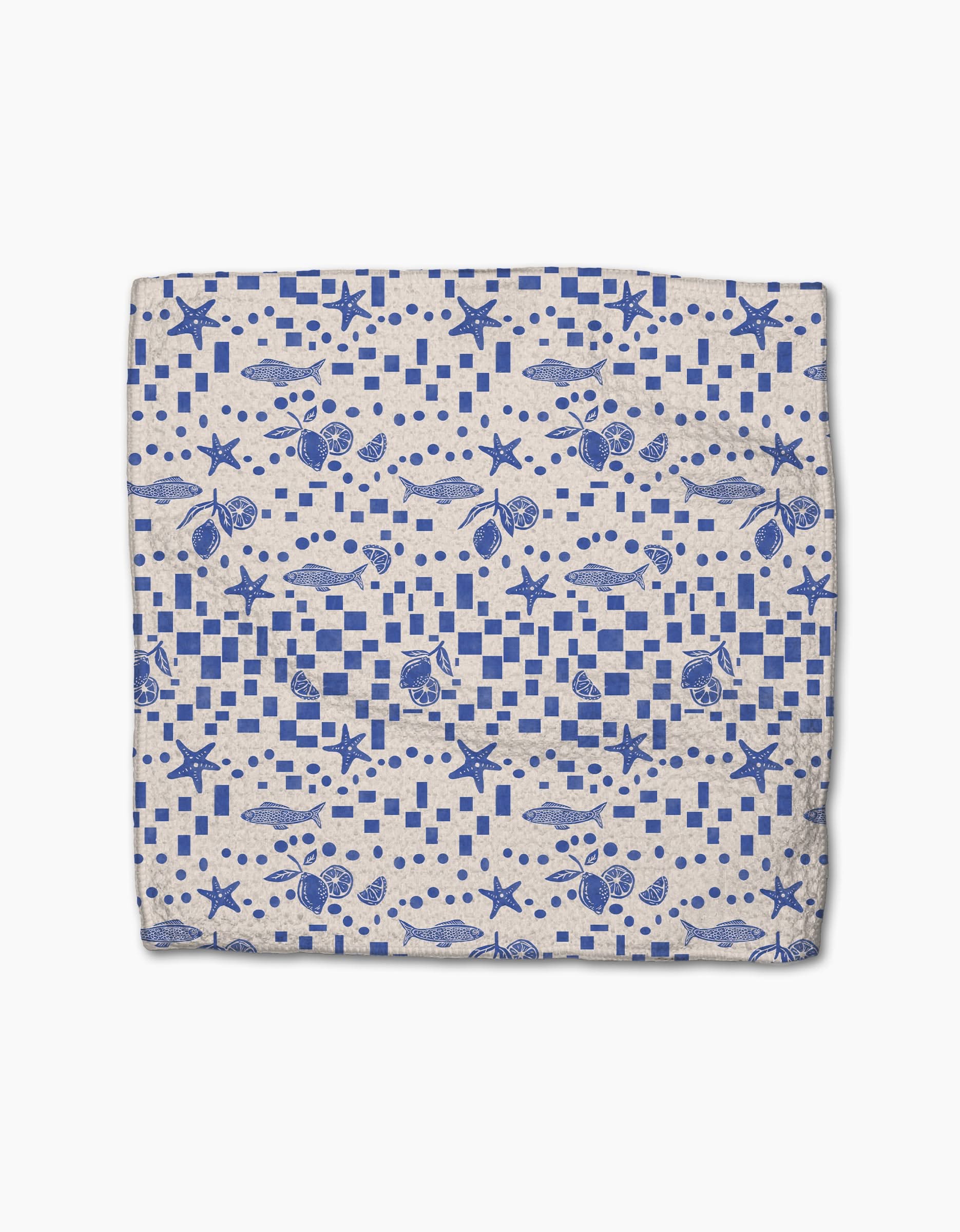 The Santorini Tile dishcloth by Geometry features a blue nautical seashell and starfish pattern with geometric shapes on white, crafted from durable Geoweave fabric for superior cleaning.