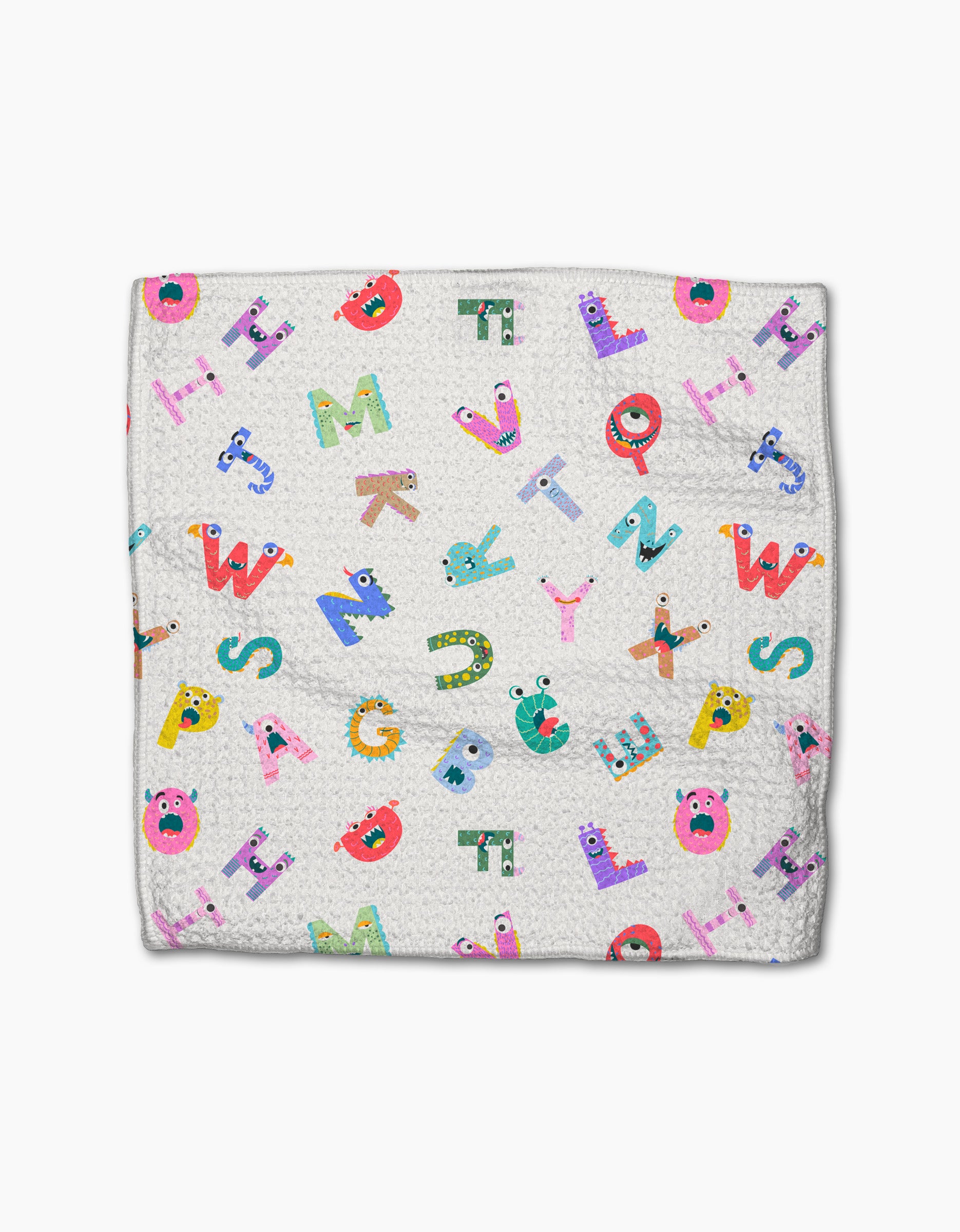 The Scribble Squad blanket by Vaishali Design Studio is a white, textured throw made from recycled materials, featuring colorful cartoon alphabet letters with playful faces scattered across the surface.