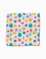 The Scribble Squad blanket by Vaishali Design Studio features a colorful pattern of cartoon monsters in unique shapes and colors on a white background, made from recycled materials for an eco-friendly, playful touch.