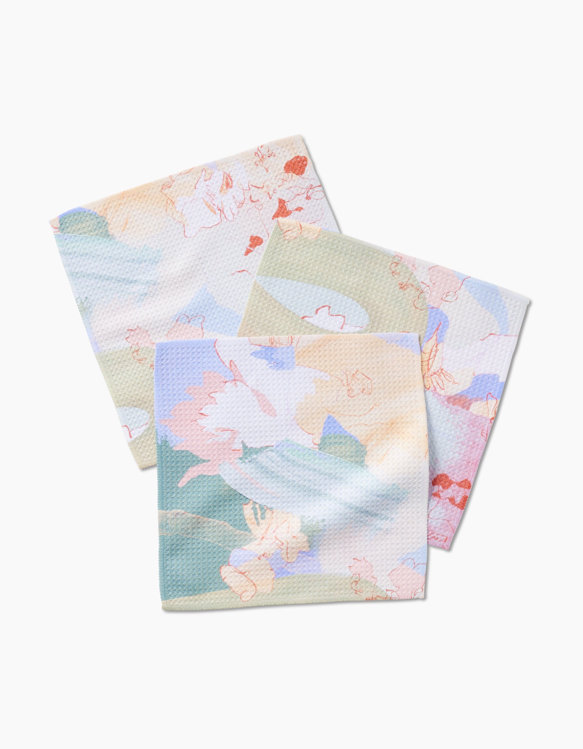 Three Secret Fort cloth napkins by Kristina Baker, made from recycled materials, feature a soft pastel abstract floral pattern and are displayed slightly overlapping on a white background.