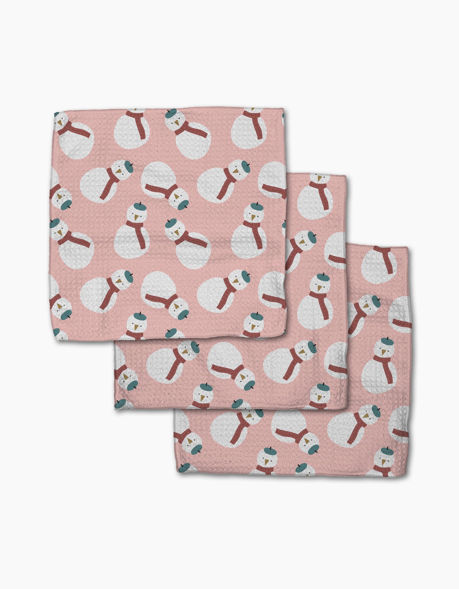 Set of three pink washcloths from Jennifer Bouron, each with a repeating pattern of white snowmen in blue hats and red scarves. The Snowman dishcloth set is made for daily use from recycled materials.