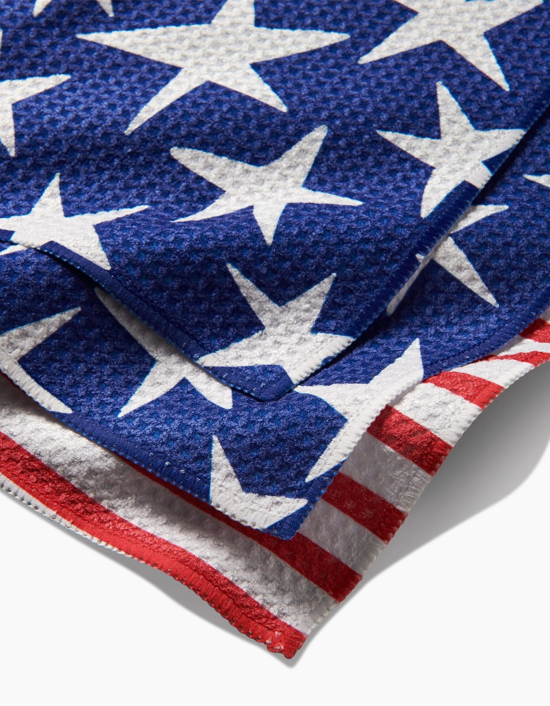 A close-up of Mindfulnices Stars And Stripes shows its textured, super-absorbent fabric featuring white stars on blue and bold red and white stripes, echoing the American flag’s iconic design.