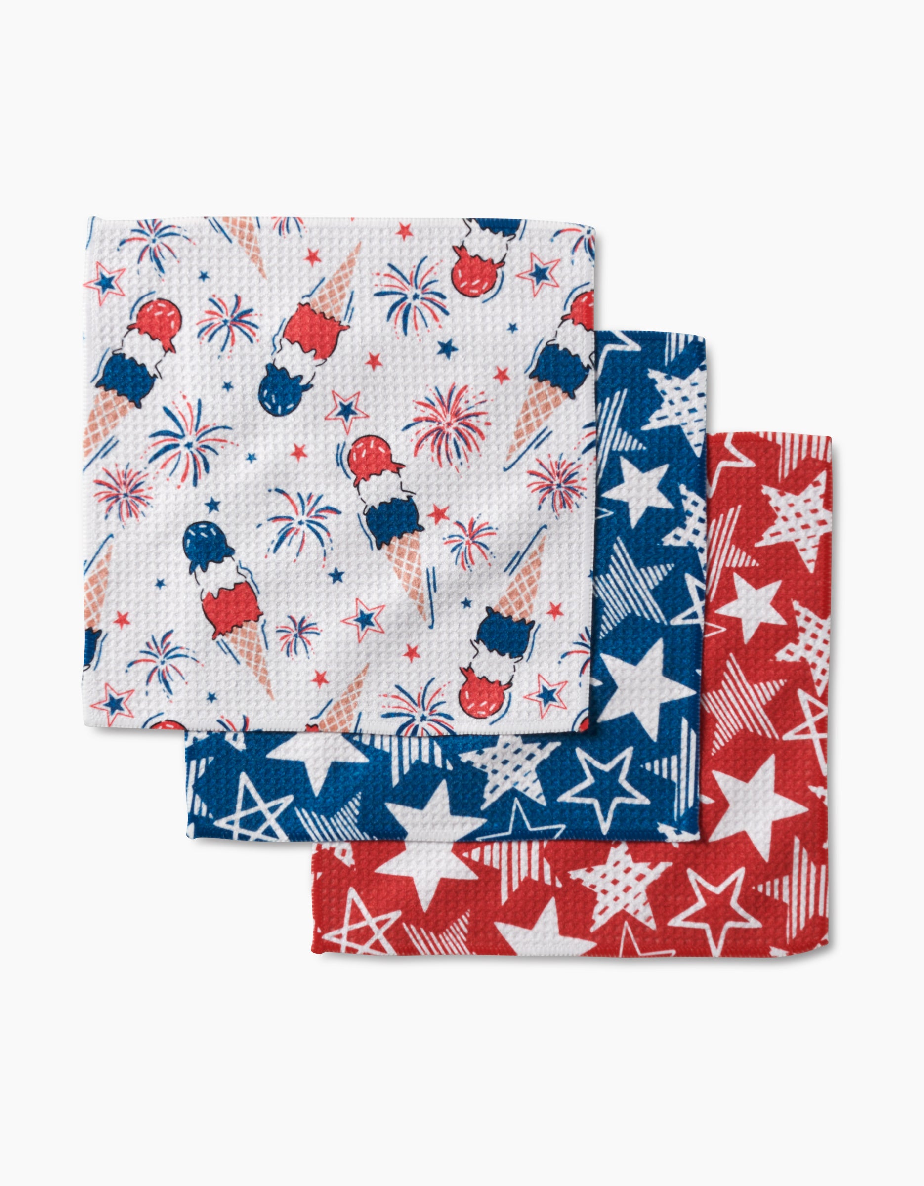 The Stars In Your Eyes Dishcloth Set by Hufton Studio includes three kitchen towels: one with red, white, and blue ice pops and fireworks, one blue towel with white stars, and one red towel with white stars.