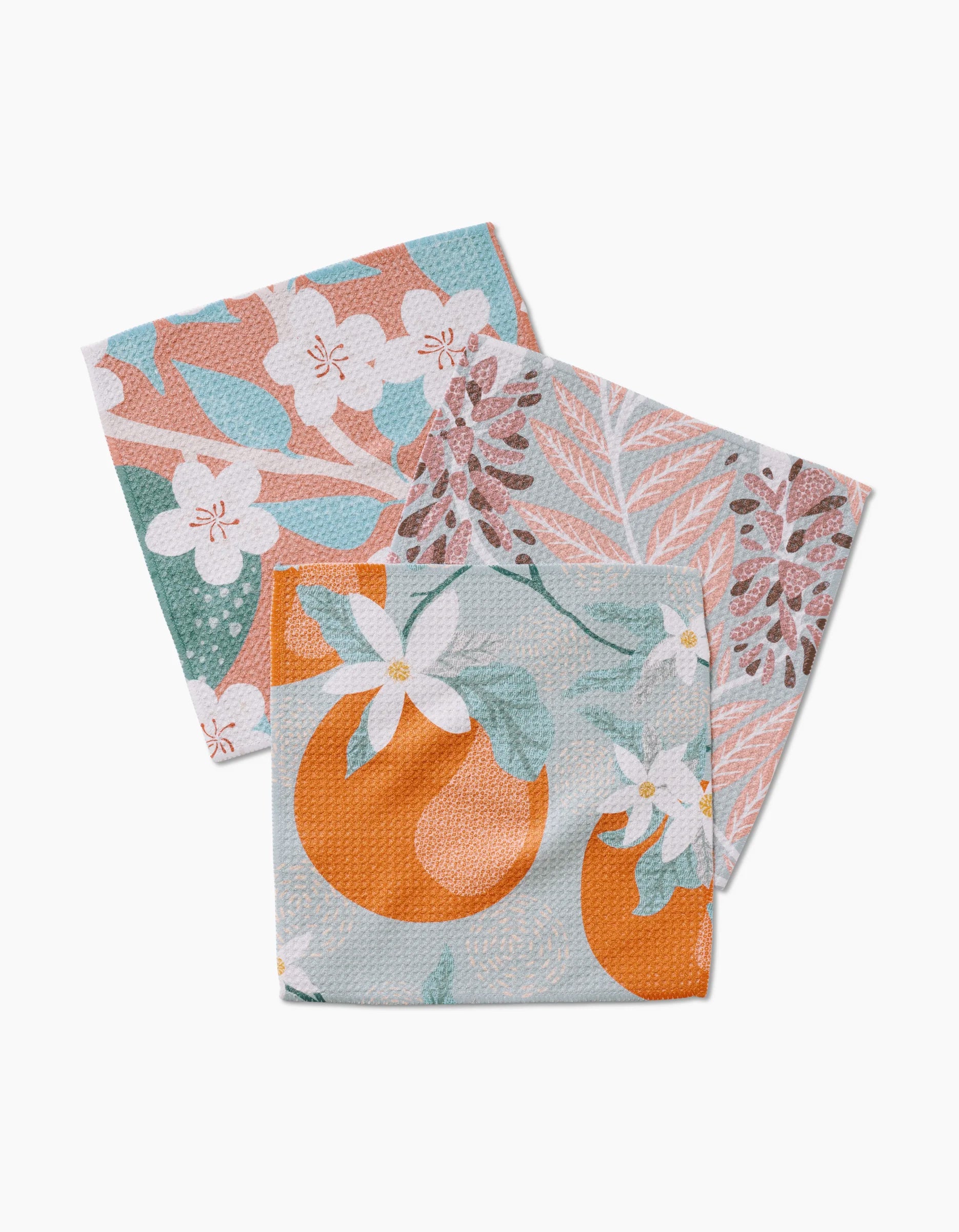 The State Flowers dishcloth set by Julianne Haness includes three square, super-absorbent cloths with floral and botanical prints in pastel pink, green, and orange. Made from recycled materials for an eco-friendly touch.