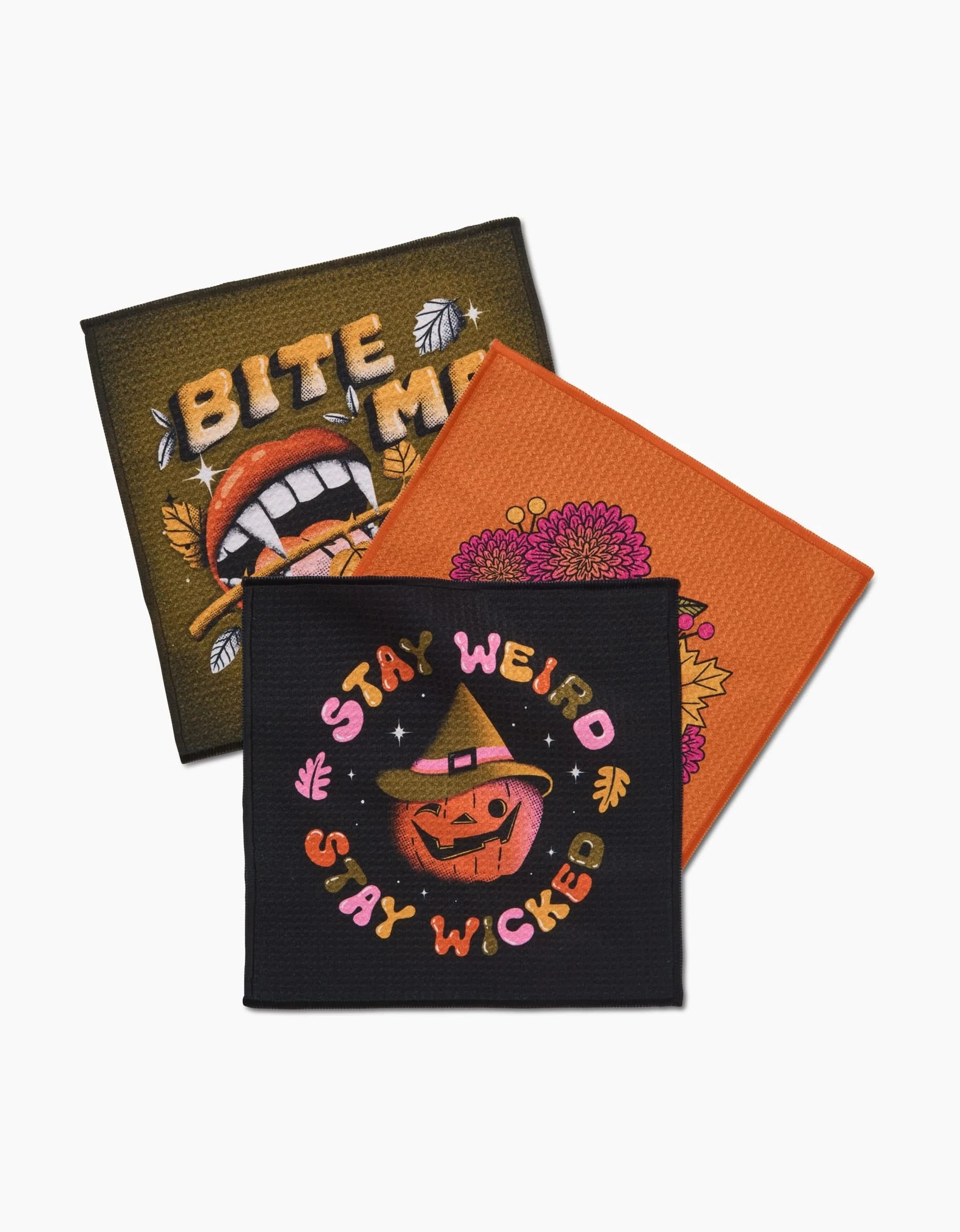 The Stay Weird Stay Wicked patch set by Megan Roy includes three colorful recycled fabric patches: one reading BITE ME with vampire teeth, one with orange flowers, and one with STAY WEIRD STAY WICKED and a smiling pumpkin.