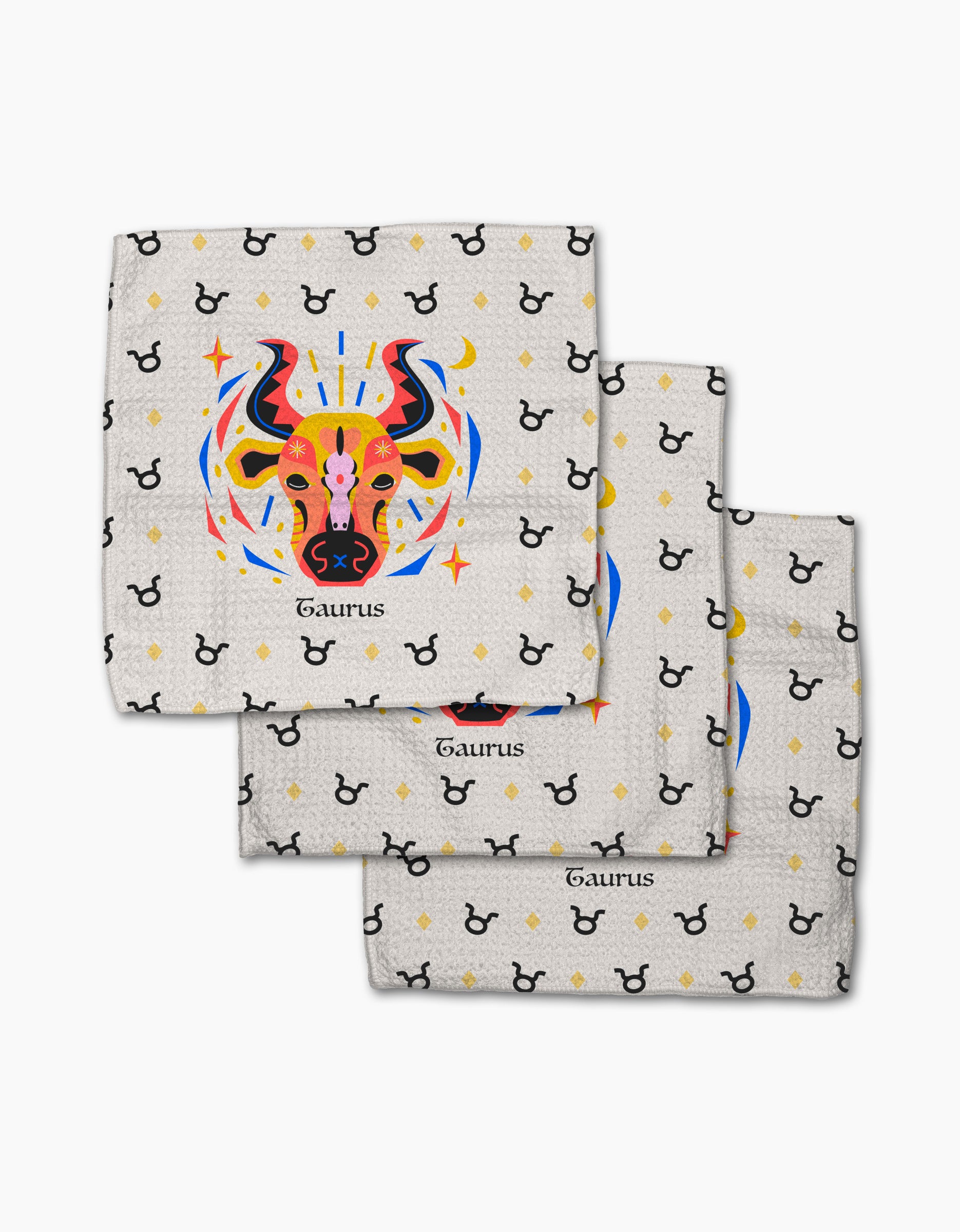 Three Steady Taurus napkins by Heather Zhou are stacked, each showing a colorful bull head with “Taurus” beneath. Made from recycled materials, the background has repeating black Taurus symbols and yellow dots.