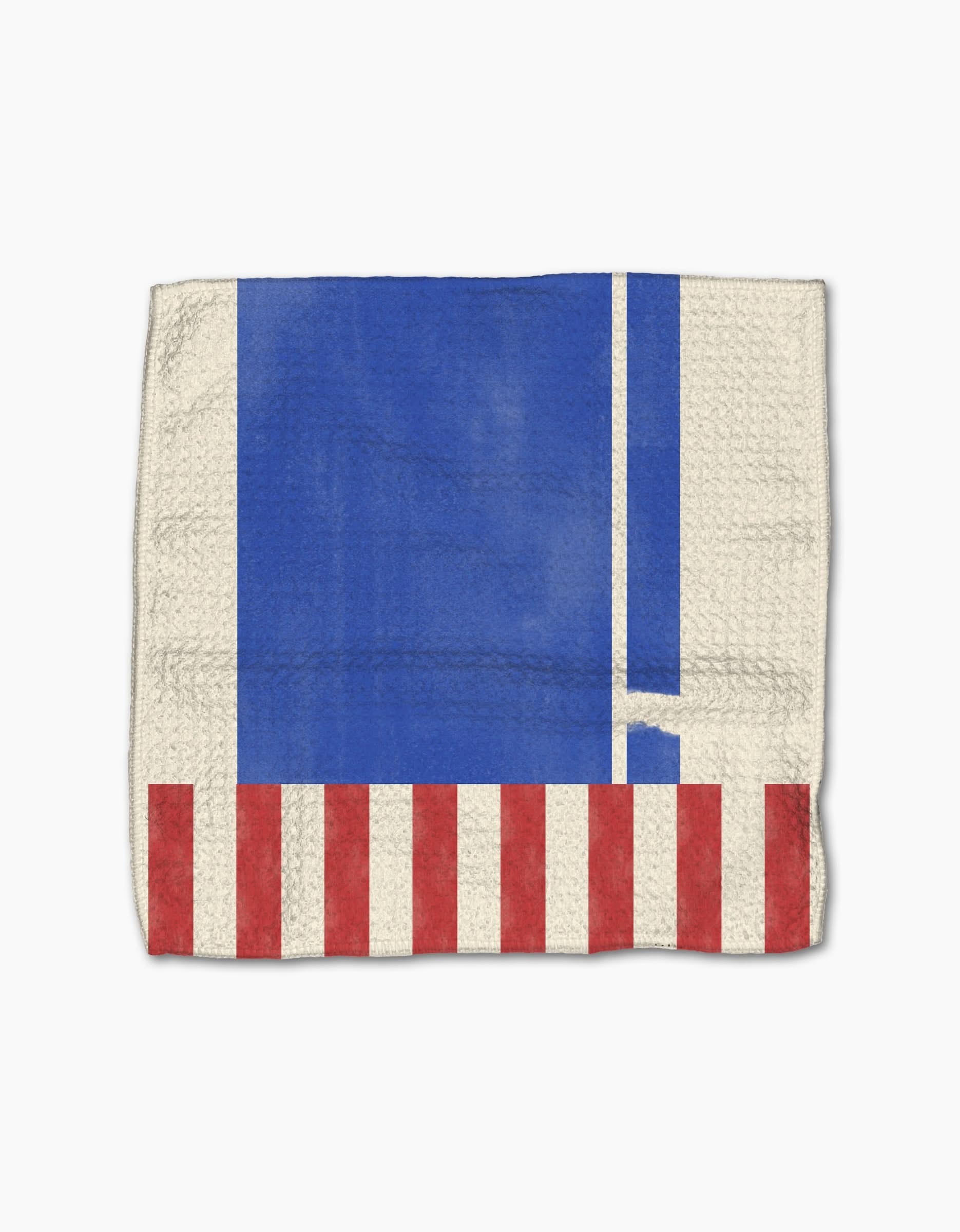 The Geometry Striped Heart dishcloth is made from recycled materials and features a blue rectangle, two white vertical stripes, and red and white stripes along the bottom edge on a beige background.