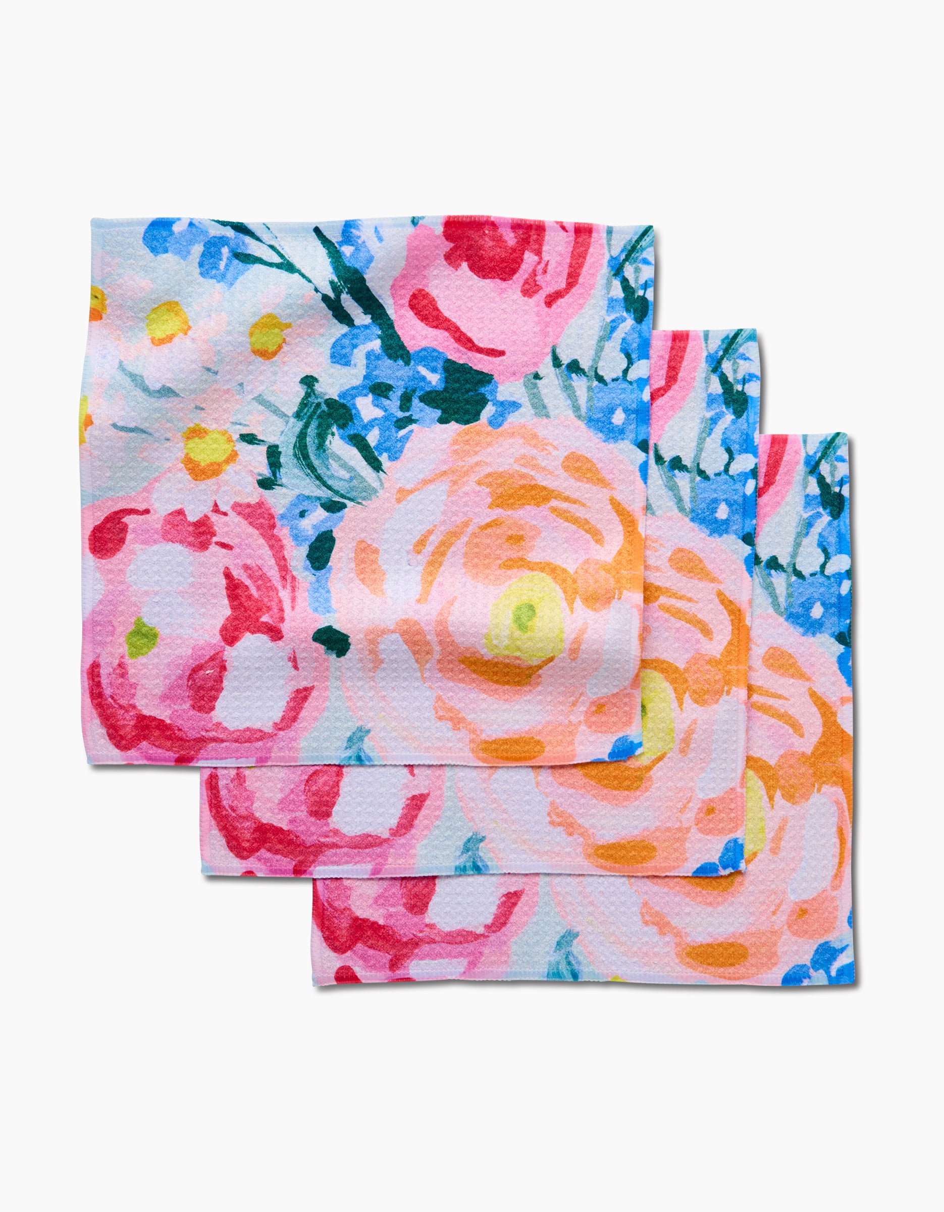 The Suzzy napkins by Ania Zwara Art are a set of three rectangular cloths made from recycled materials, showcasing a colorful floral pattern with pink, peach, and red flowers plus blue and green accents on a white background.