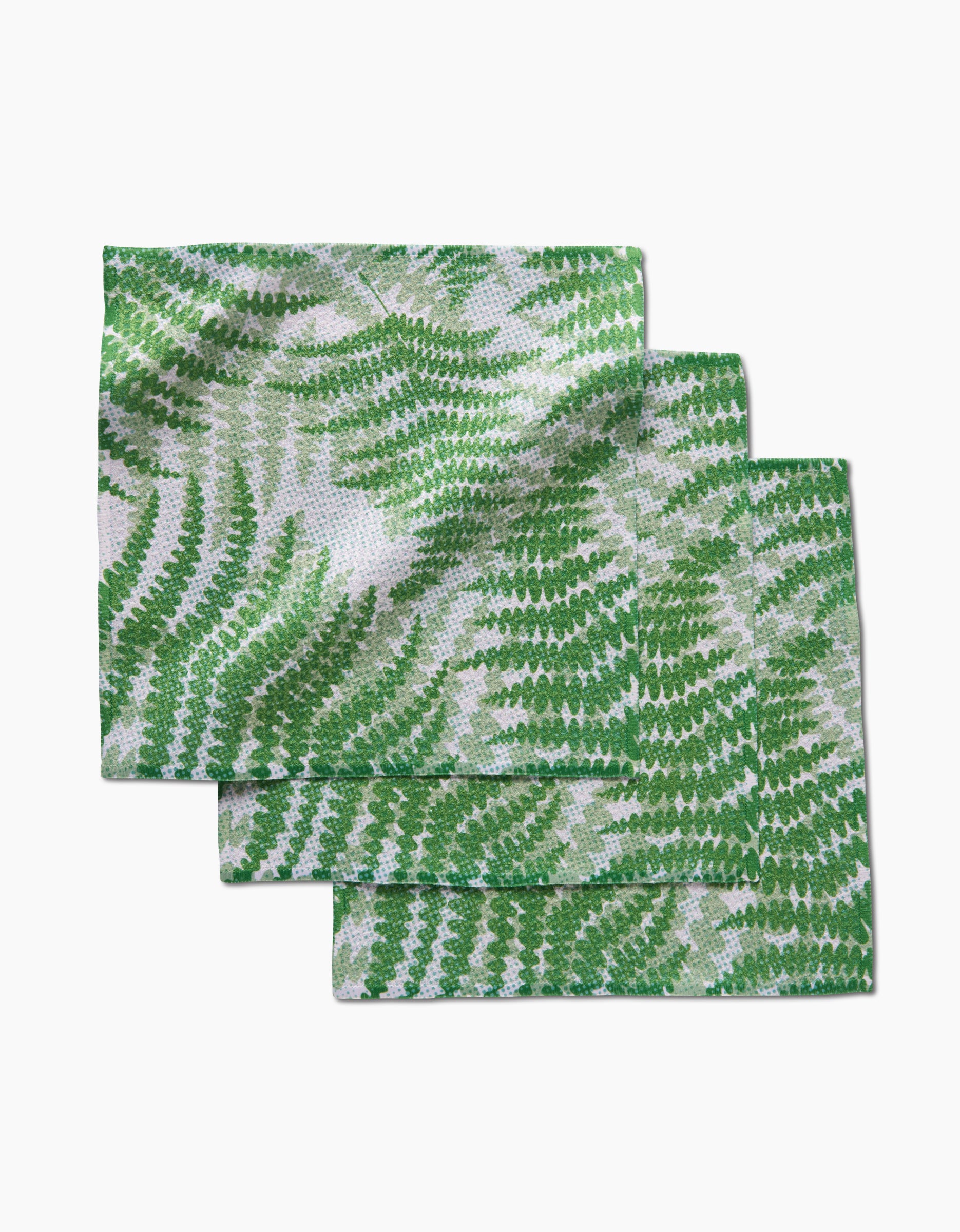 Three rectangular GEOMETRY dishcloths in the Swaying Leaf pattern, made from Geoweave fabric and showcasing green fern leaves, are stacked slightly offset on a white background.