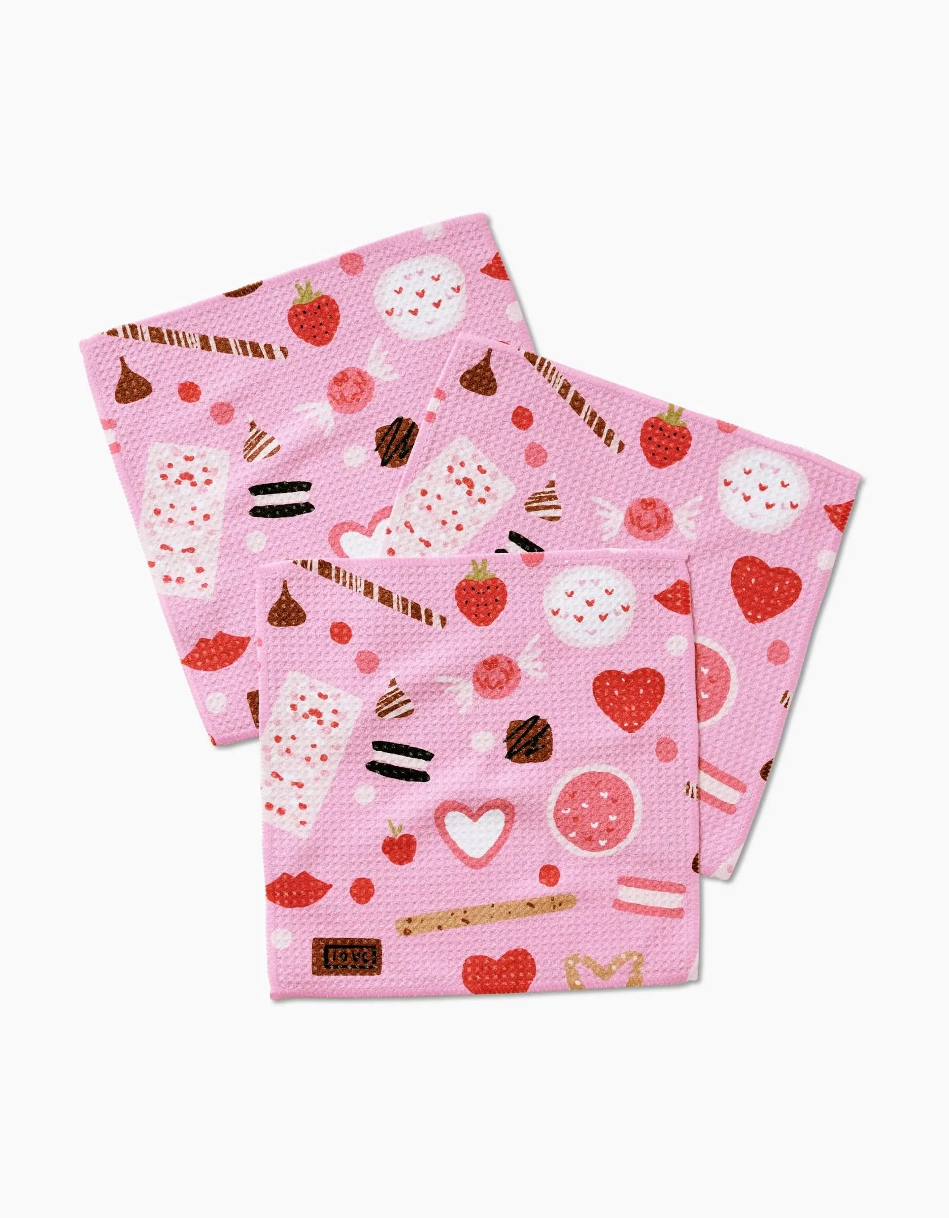 Sweet Lovin by Janna Sue Design: a set of three pink recycled napkins with assorted sweets—strawberries, chocolate sticks, cookies, donuts, and hearts—on a white background.