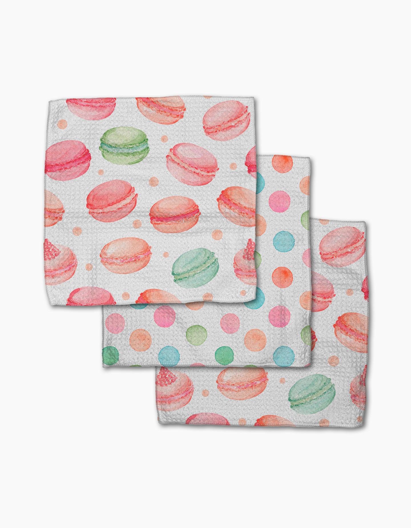 Three Sweet Macarons napkins by Elena Fay, made from recycled materials, feature a watercolor design with pink and green macarons and multicolored polka dots on white, arranged in a neat layered stack.