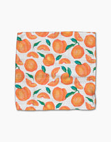 The Sweet Pickings dishcloth by Aubrey Fairchild features a vibrant pattern of whole peaches, peach slices, and green leaves on ultra-absorbent Geoweave fabric.