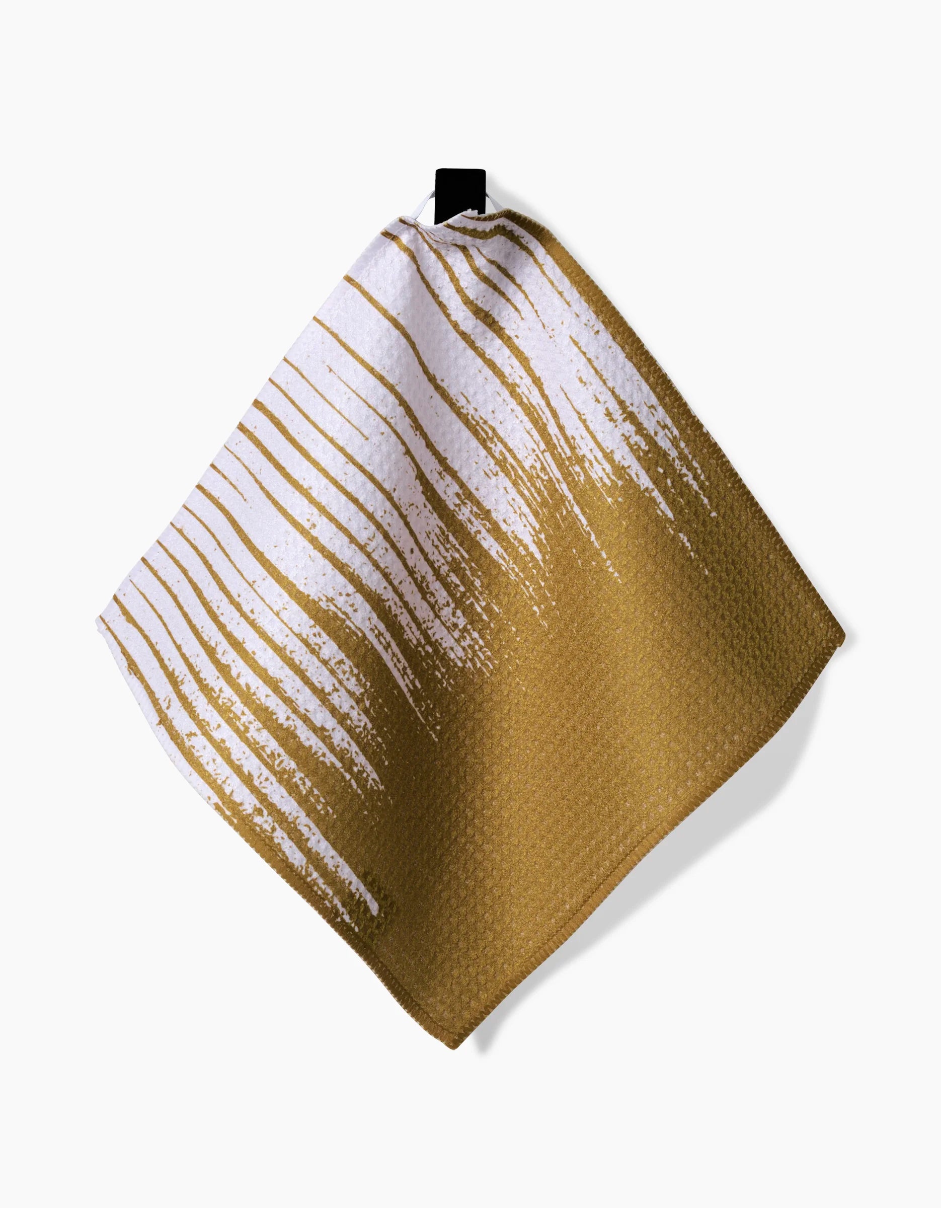 The GEOMETRY This And That dishcloth features a textured square design with a gold base and white streaks, hanging by a black loop against a white background—crafted from recycled materials for eco-friendly cleaning.
