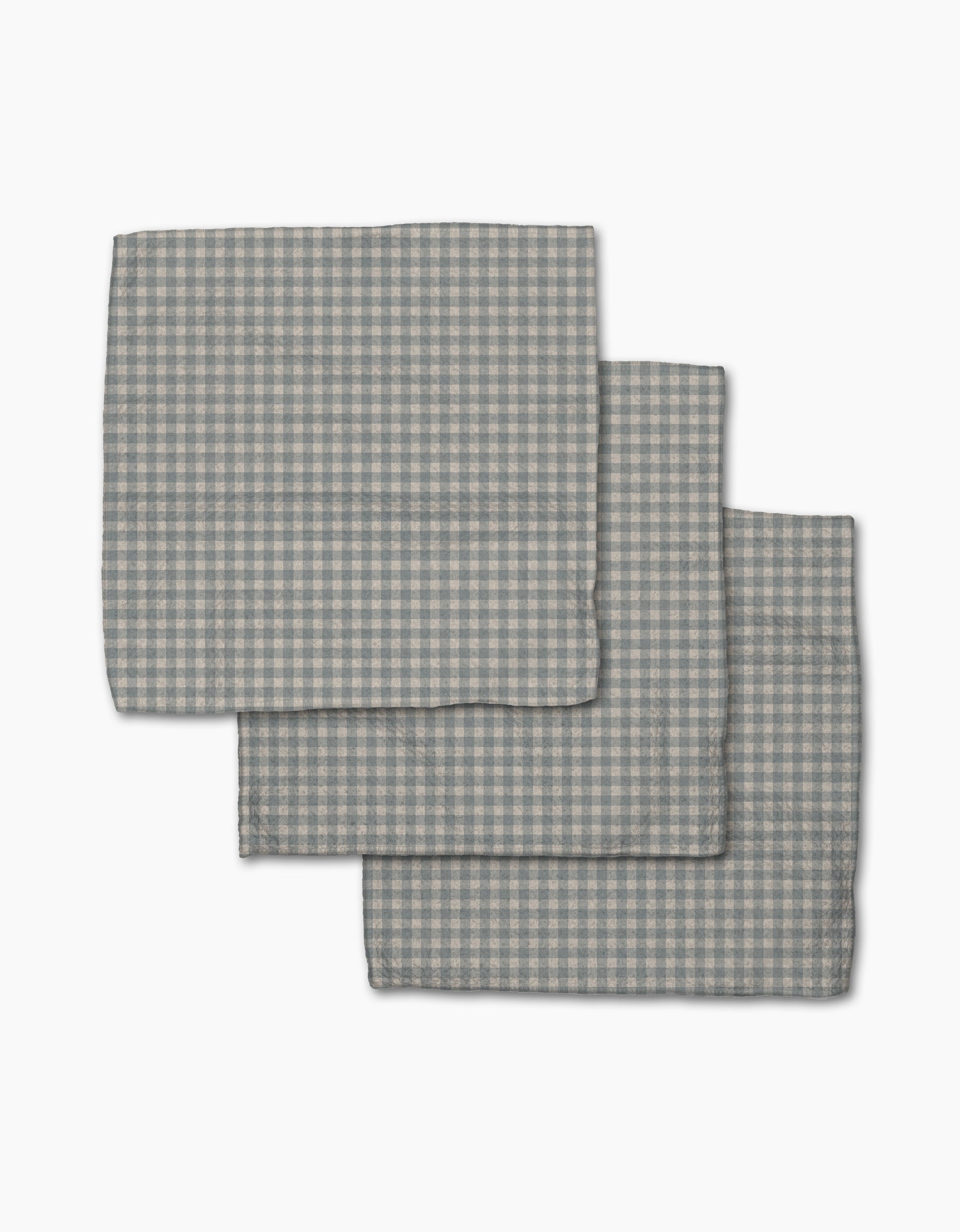 Three folded Tidepool Check napkins by Jenny Keller, featuring a gray and white gingham pattern, are stacked on a white background—ideal as stylish recycled dishcloths or a dishcloth set for your kitchen.