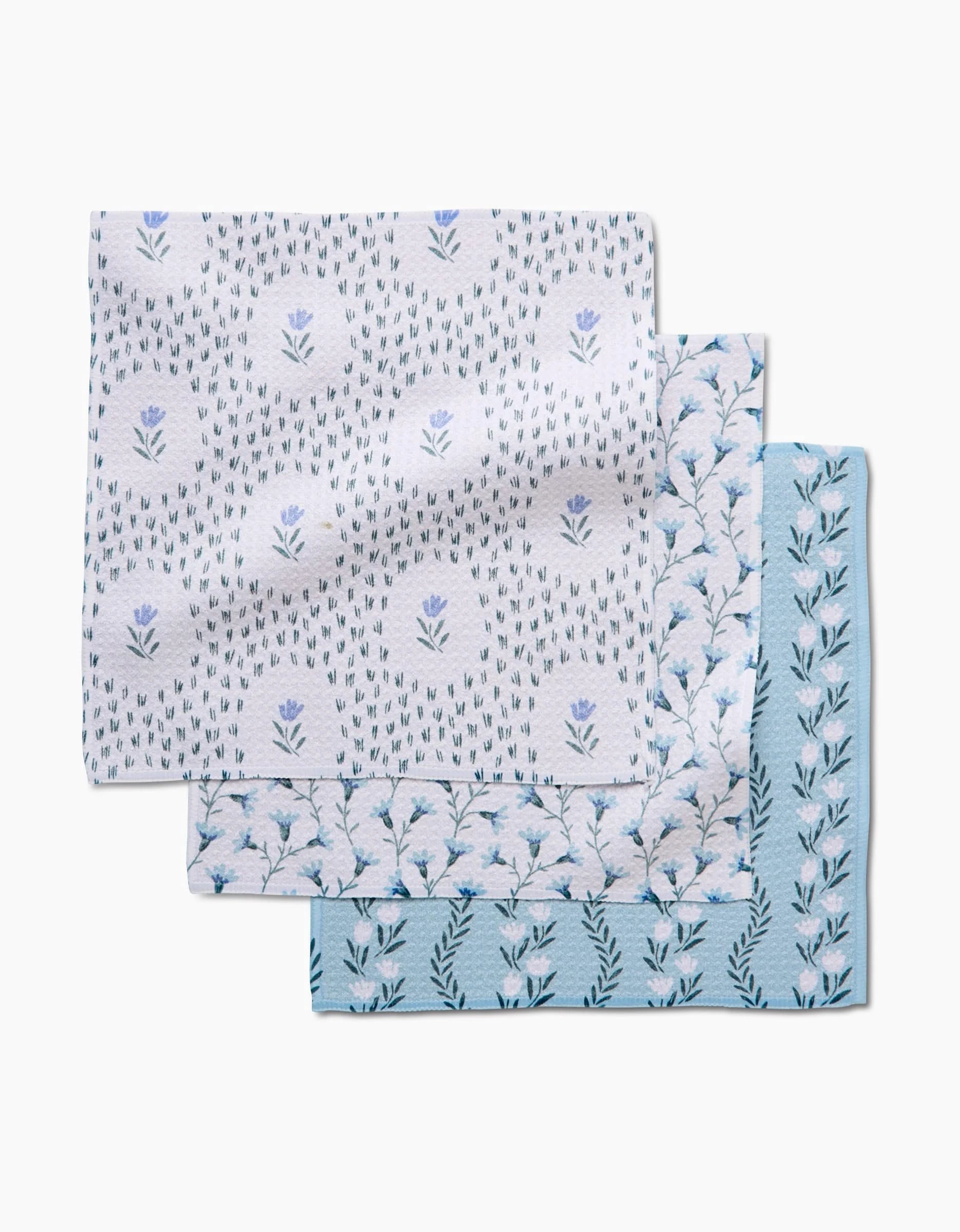 The Teri the Butter Trailing Farmhouse Florals set includes three recycled cotton napkins with blue and white floral patterns—each featuring unique yet coordinated designs on a white background.