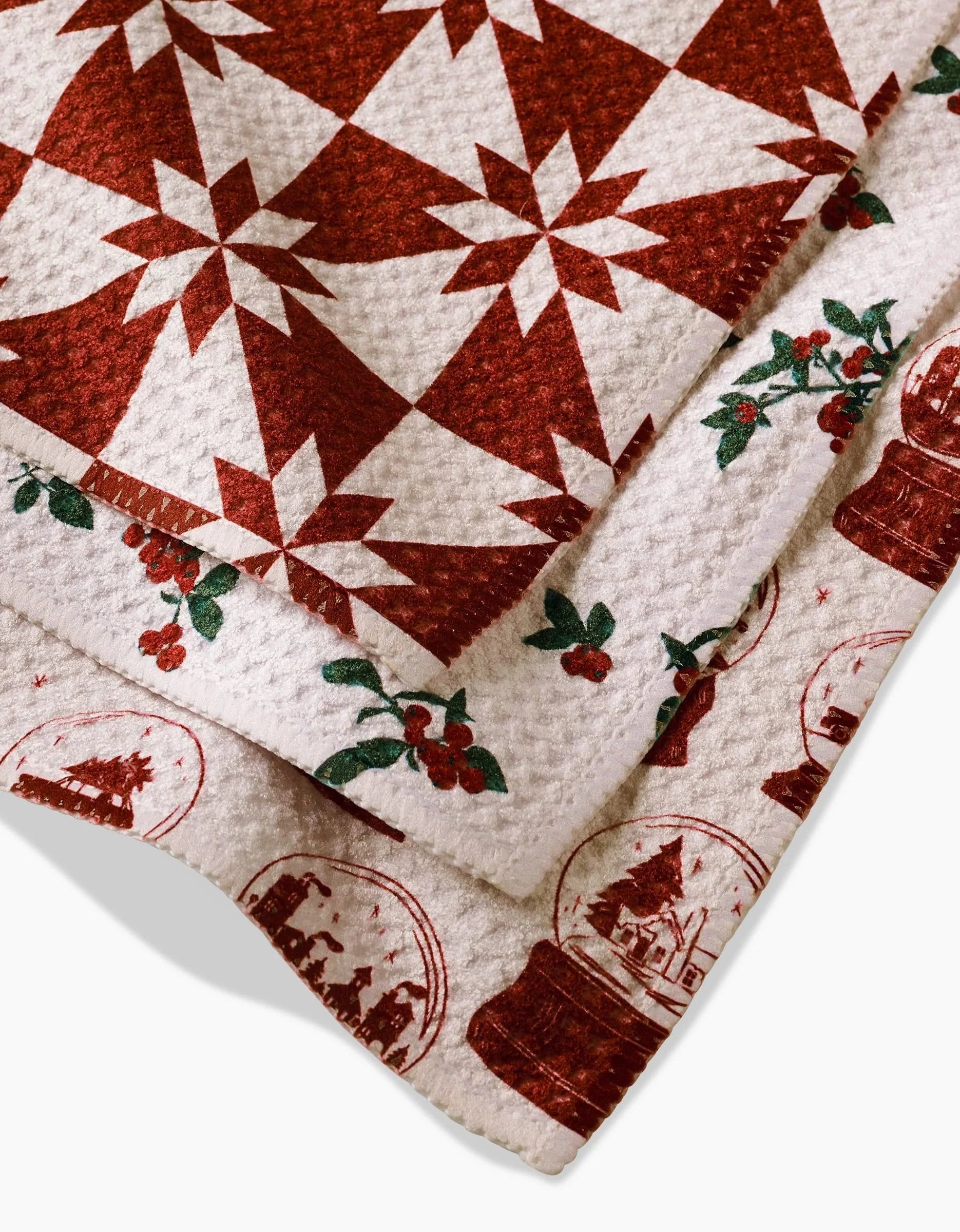 The Aubrey Fairchild Vintage Christmas set features three festive fabric pieces: a red star quilt-patterned dishcloth, a print with red berries and green leaves, and one with red snow globe winter scenes on white.