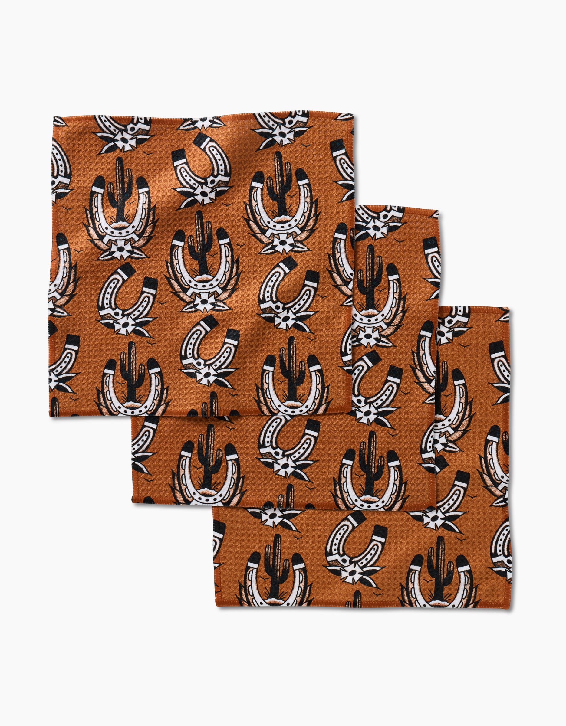 Three Western Horseshoes bandanas by Cole Strem, made from recycled materials with a black and white cacti and horseshoe pattern, are stacked in a staggered arrangement against a white background.