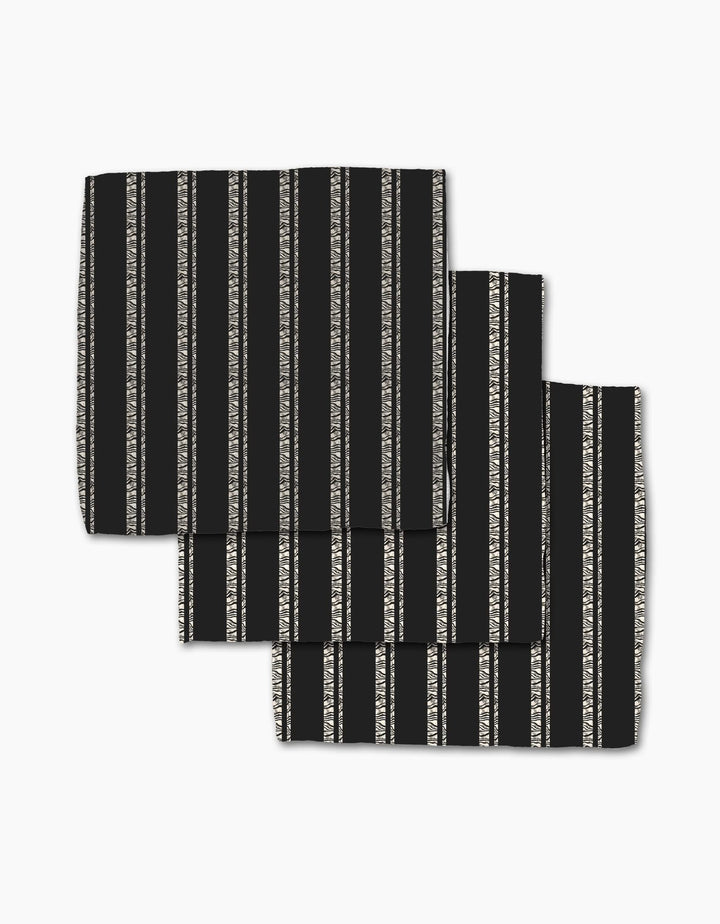 Three Zebra Pin Stripe Black cloth napkins from Geometry, made with Geoweave fabric and featuring vertical white and gray stripes, are neatly folded in a slightly overlapping arrangement on a white background.