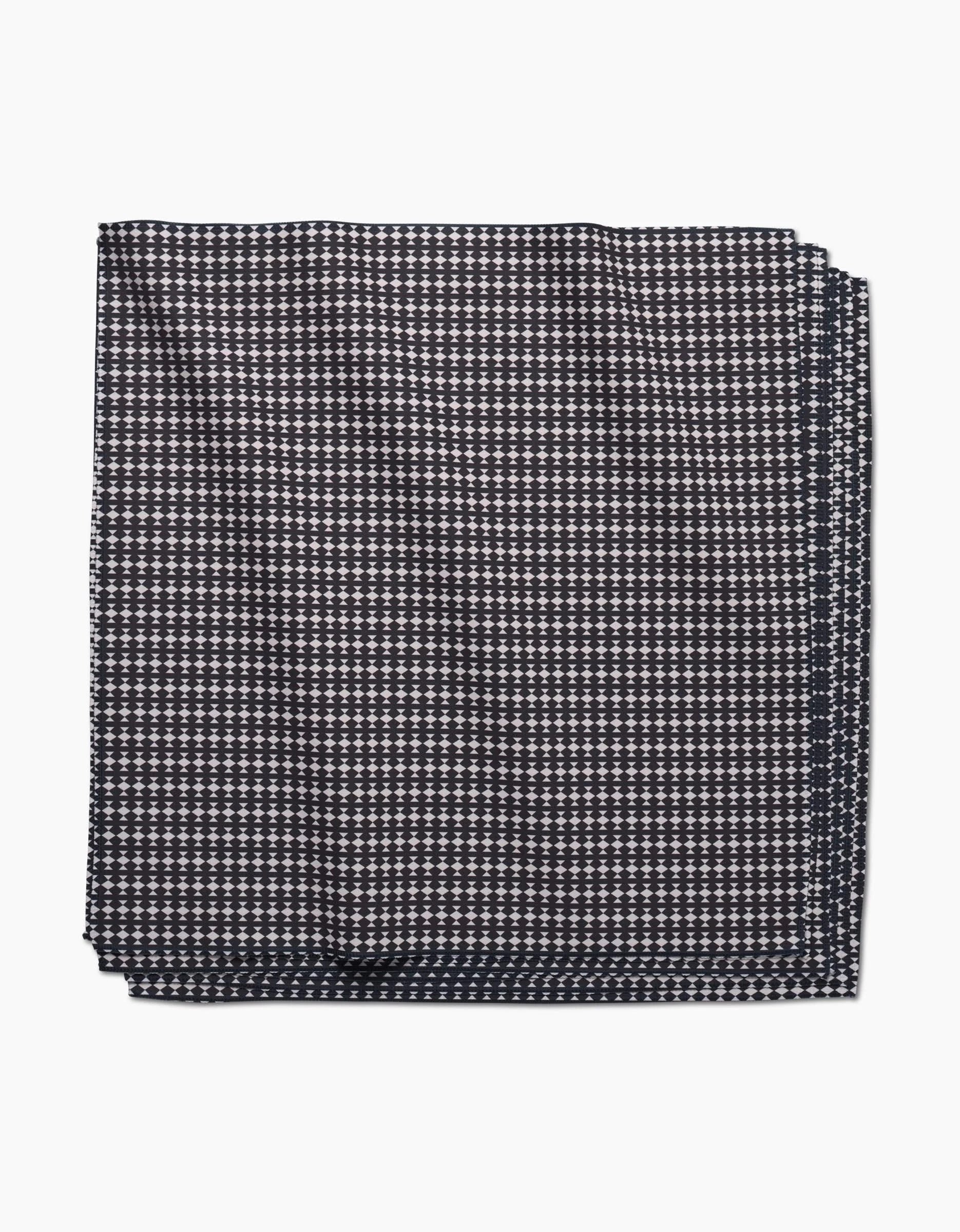 The Maori pocket square by GEOMETRY is crafted from Geosuede fabric in a dark hue, featuring a small white geometric dot pattern on a plain background.