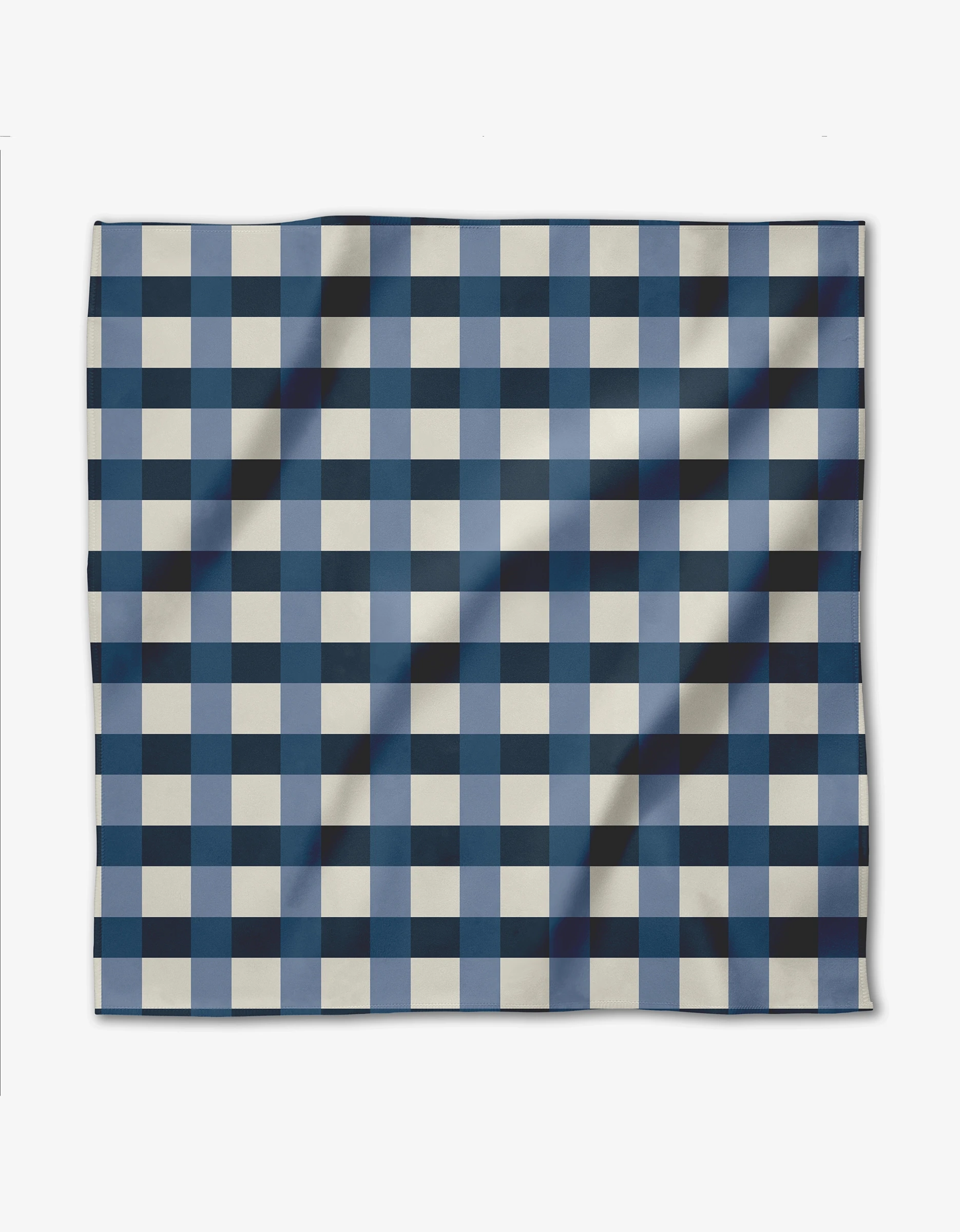 The GEOMETRY Seafaring dinner napkin features a blue and white checkered grid pattern on Geosuede fabric, shown slightly wrinkled and laid flat against a white background.