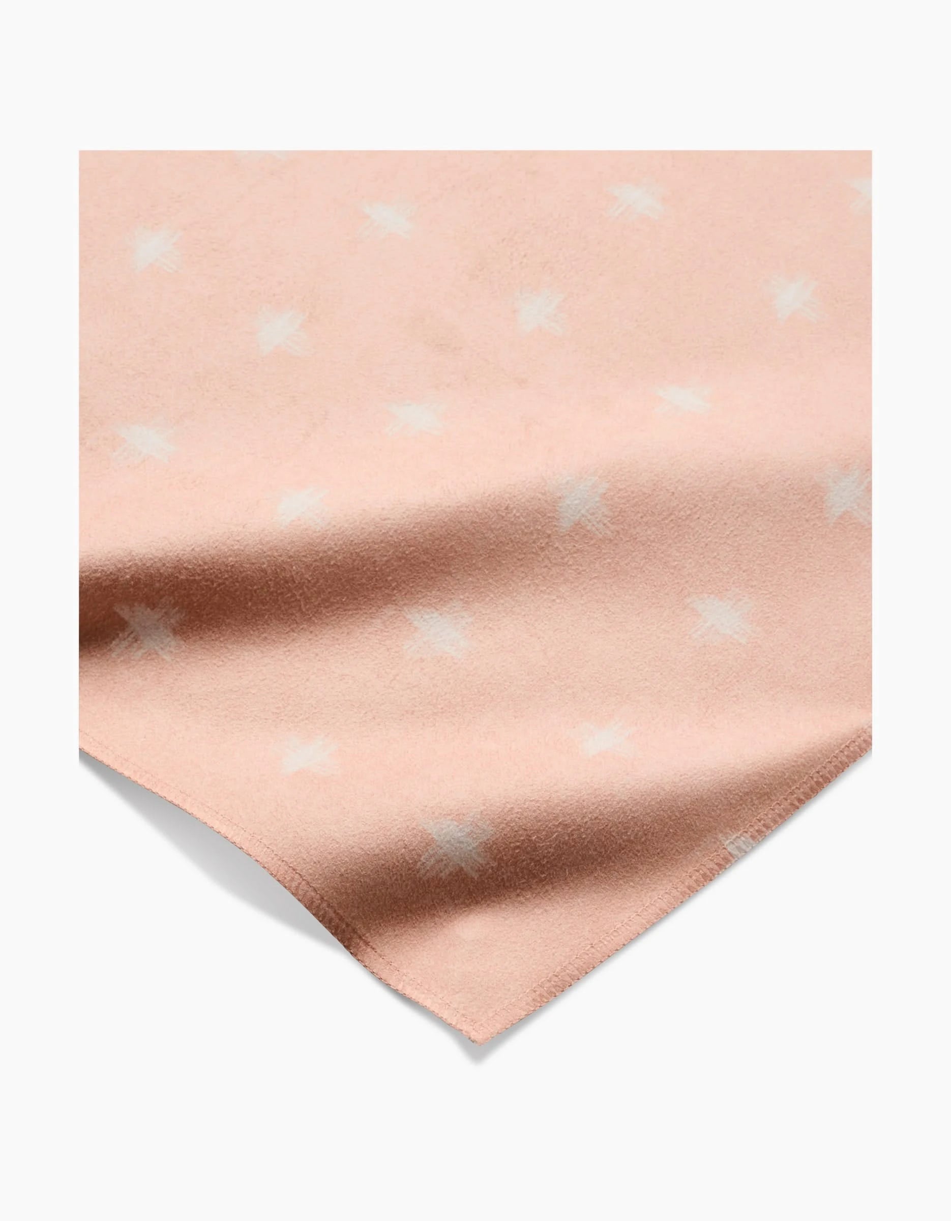 Aveline by Amy MacCready features soft, light pink Geosuede fabric with white, scattered star-like patterns. Draped to show its gentle folds and texture, it’s perfect for creating elegant dinner napkins.