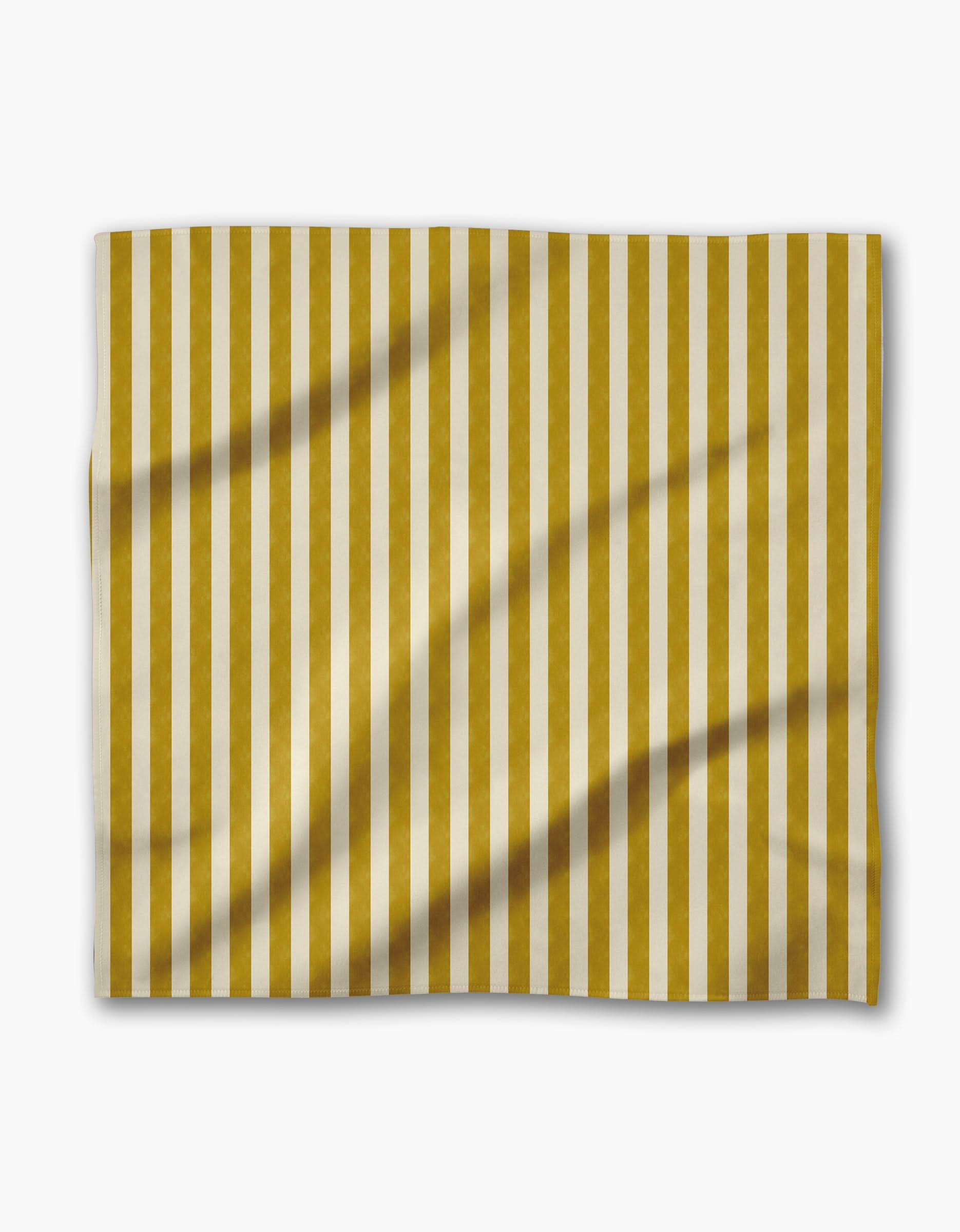 The Geometry Bauhaus Stripe dinner napkin features vertical gold and white stripes on Geosuede fabric, with a slightly wrinkled rectangular shape, displayed against a plain white background.