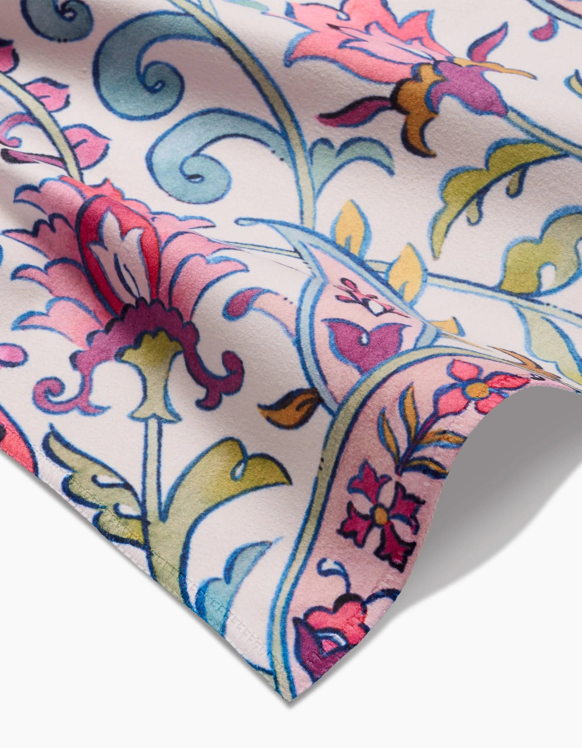 A close-up of Maayan Alper-Swans Bazaar Geosuede fabric shows a textured floral and vine pattern in pink, red, blue, yellow, and green on a light background—an eco-friendly option for any Dinner Napkin Set.