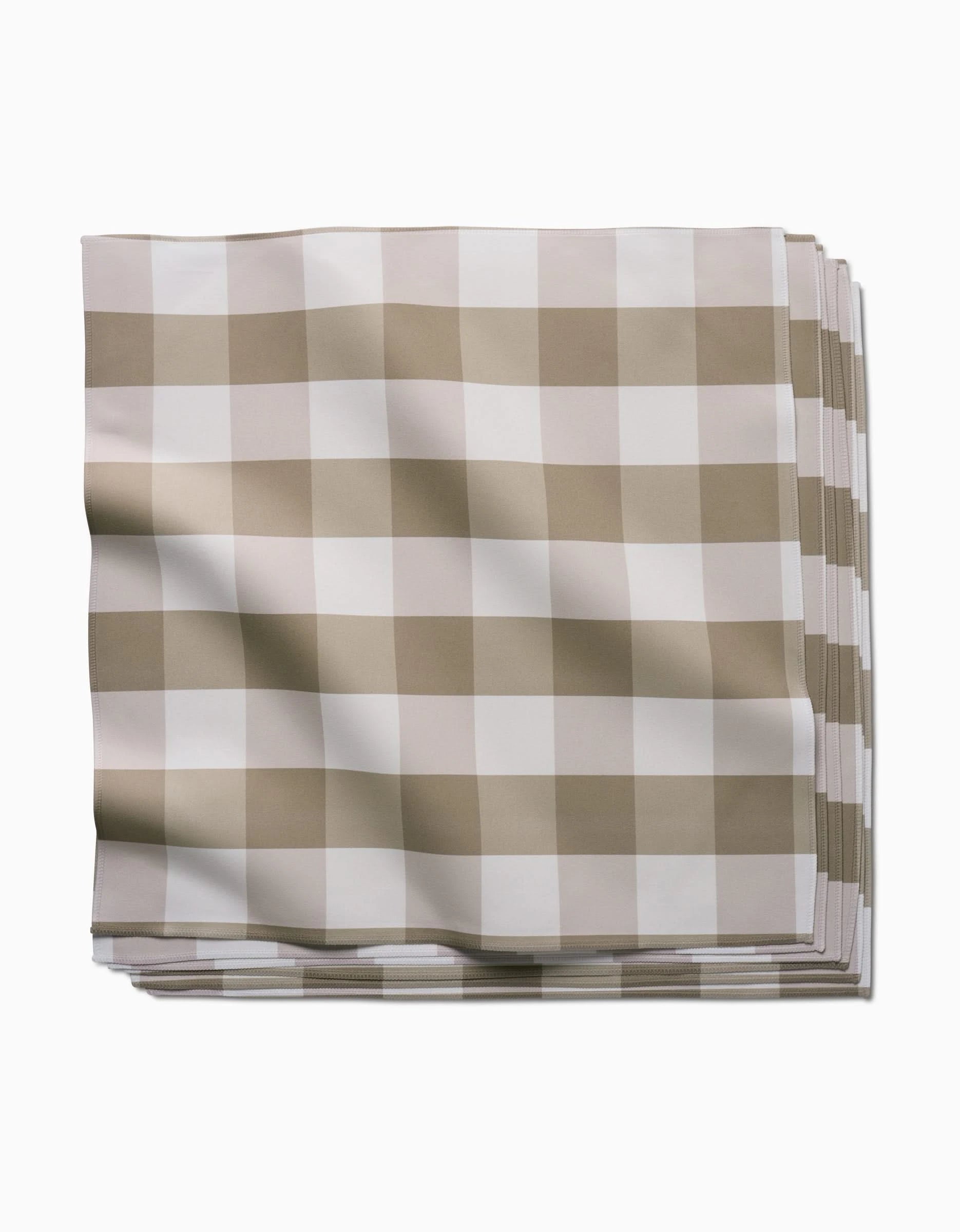 The GEOMETRY Betty Bakes folded cloth napkin, made from Geosuede fabric and featuring a beige and white checkered pattern, is displayed against a plain white background.