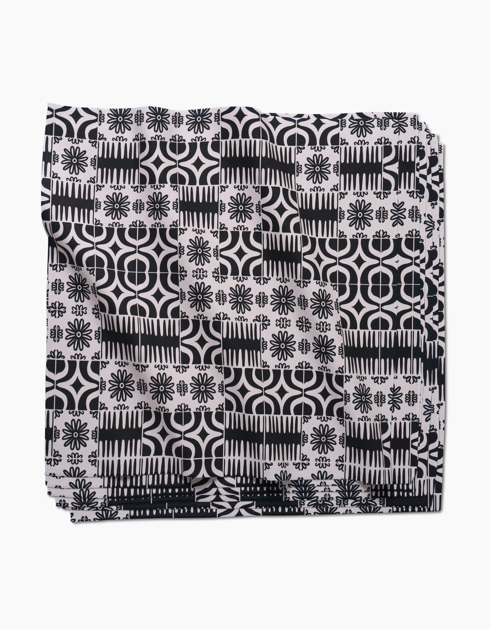 The GEOMETRY Bohemian Mosaic dinner napkin set features Geosuede fabric with a black and white geometric and floral pattern of circles, lines, and flower-like shapes on a white background.