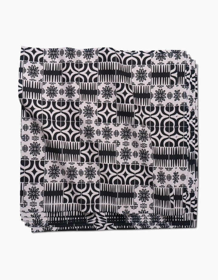 The GEOMETRY Bohemian Mosaic dinner napkin set features Geosuede fabric with a black and white geometric and floral pattern of circles, lines, and flower-like shapes on a white background.