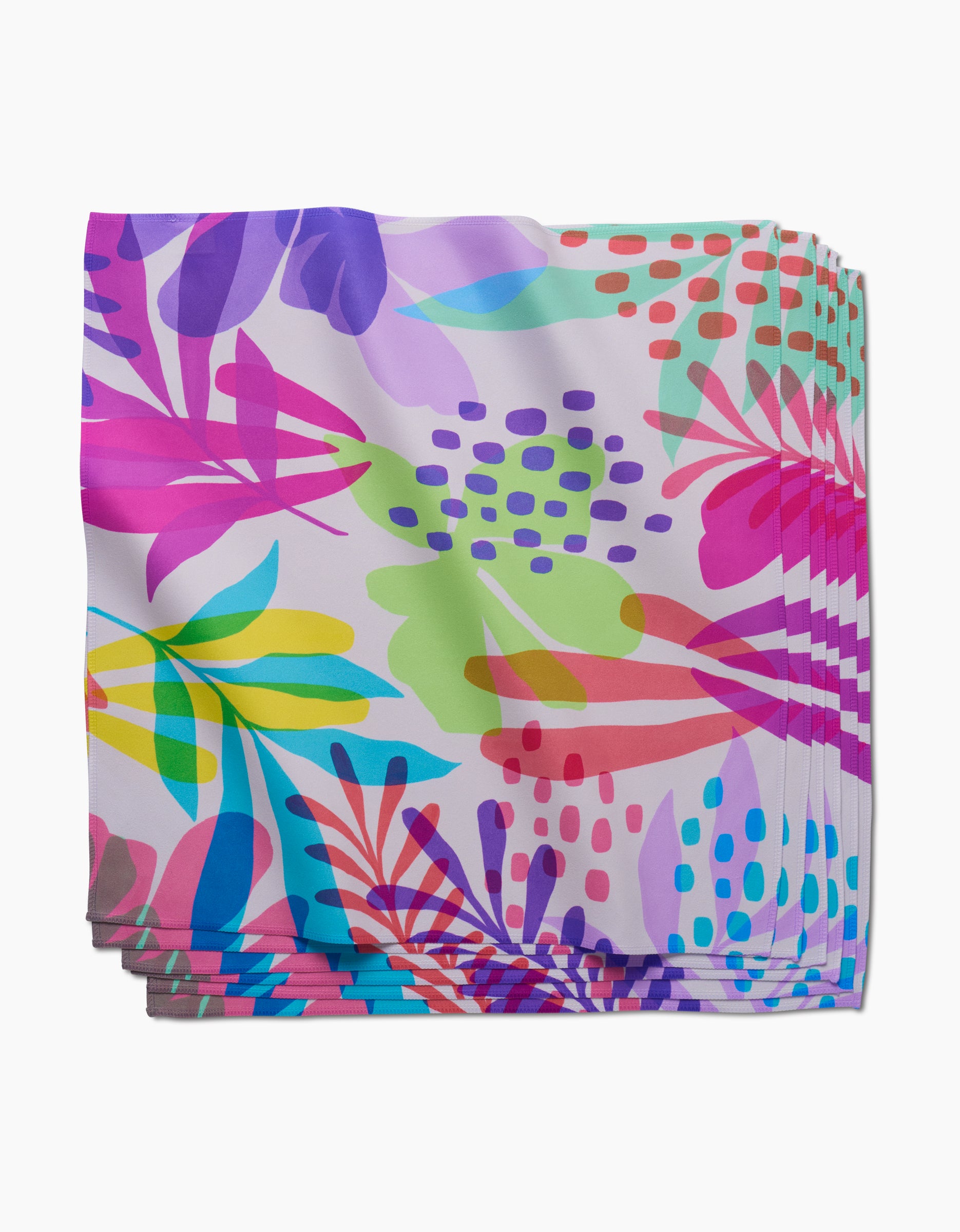 A stack of GEOMETRY Botanical Burst Dinner Napkins, featuring a colorful abstract floral pattern on white and made from recycled materials.