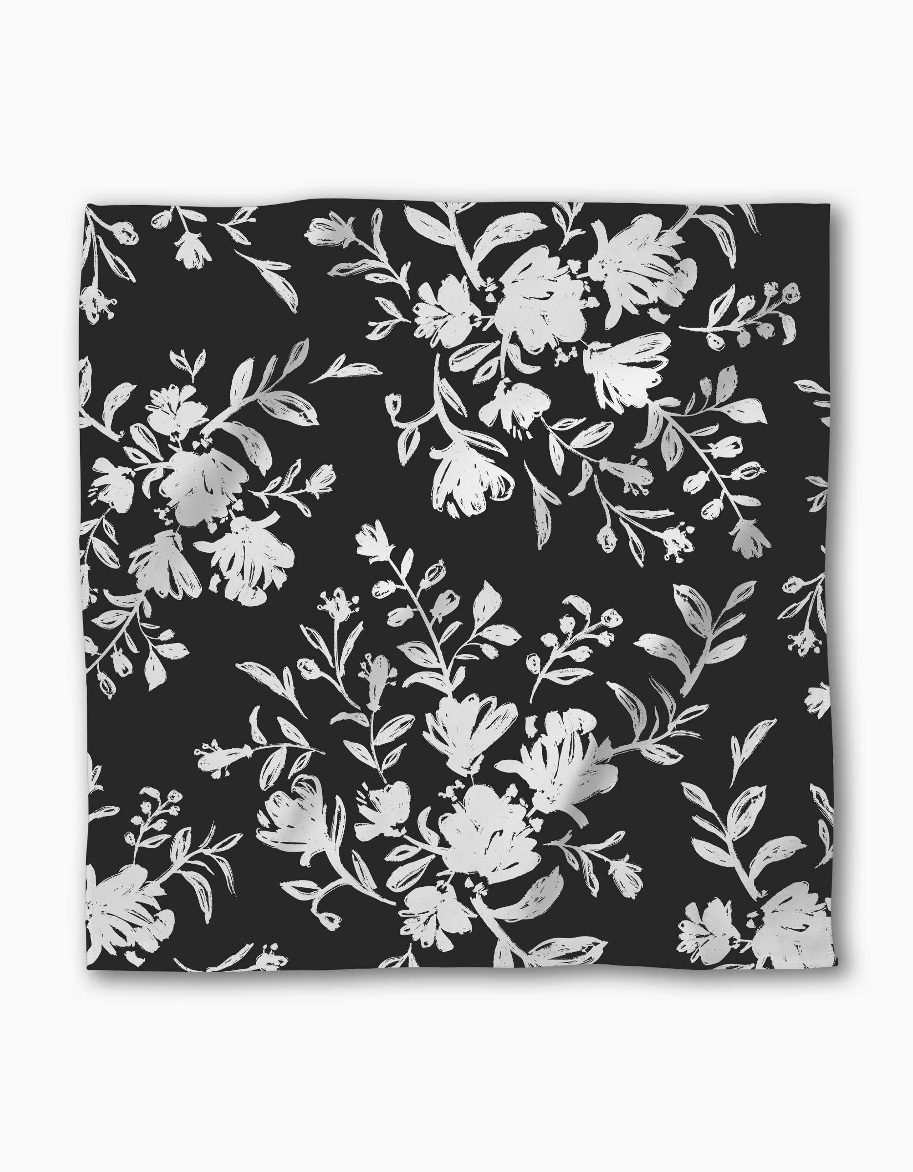 The Botanical Silhouettes Charcoal by Danelys Sidron is a square Geosuede scarf with a black base and elegant white and light gray floral patterns, creating a refined monochromatic look.