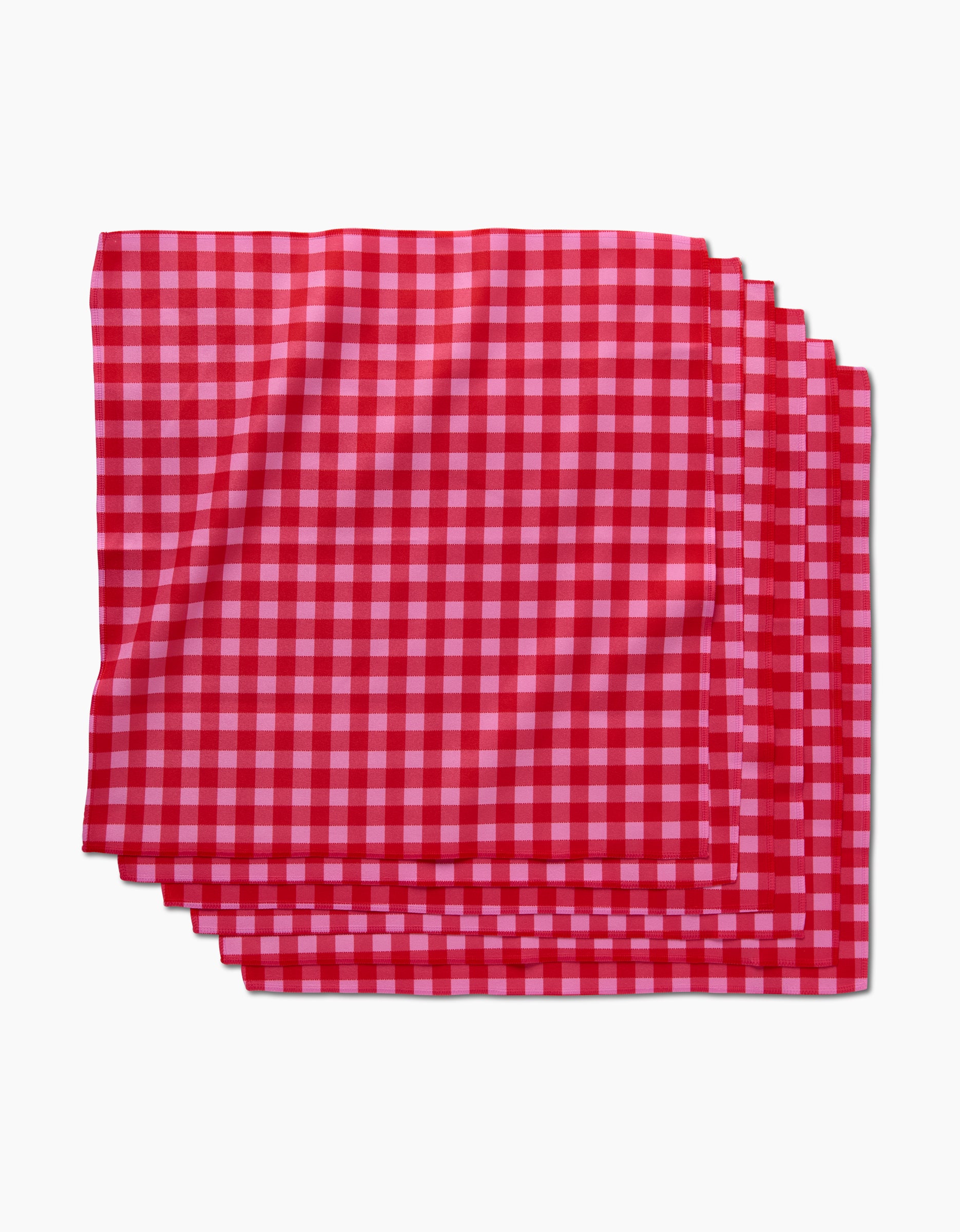 A stack of GEOMETRY Cherry Gingham dinner napkins, made from soft Geosuede fabric, neatly arranged on a white background.