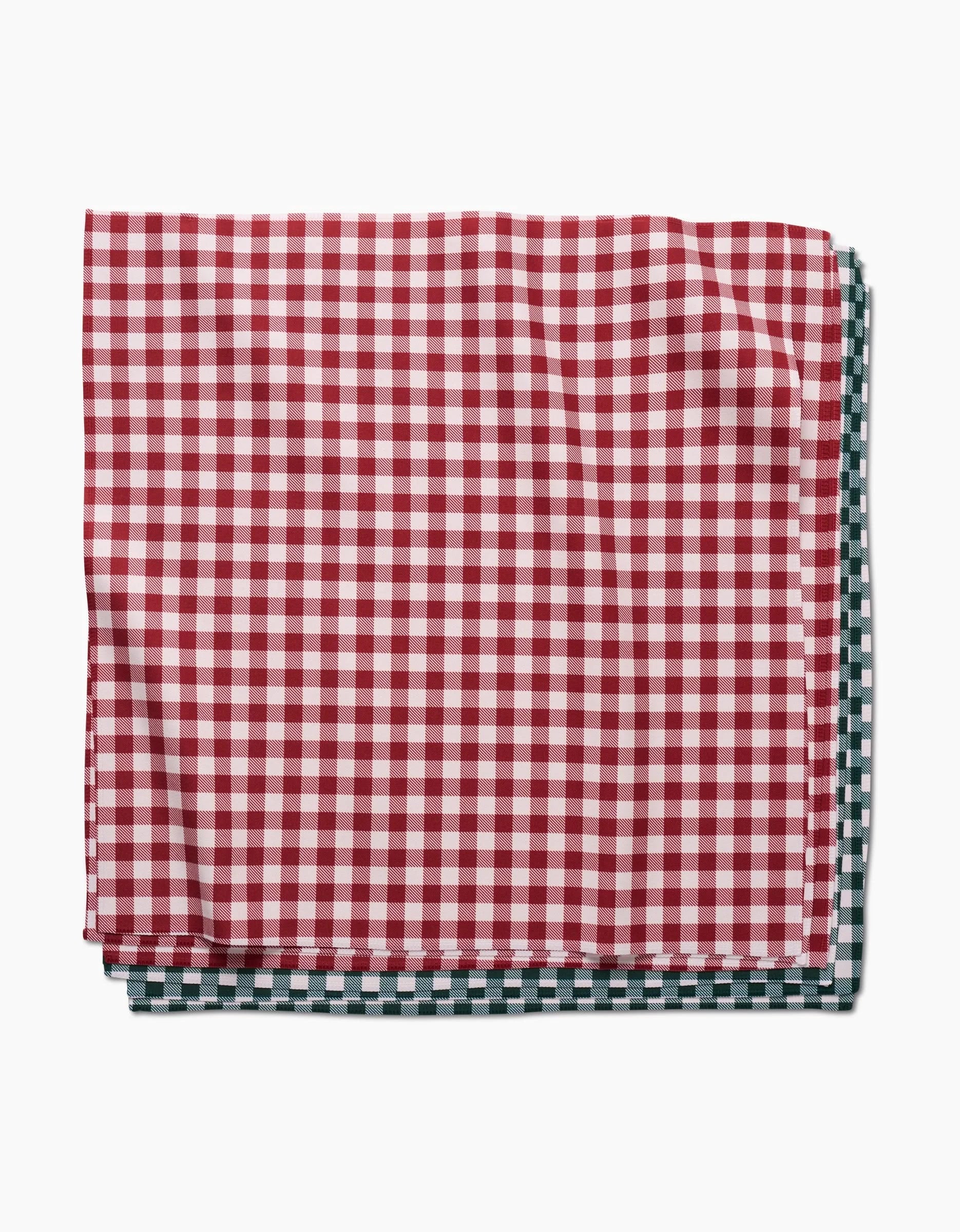 Two folded eco-friendly Aubrey Fairchild Christmas Gingham napkins—one red-and-white, one green-and-white—sit against a white background, bringing sustainable style to your table.