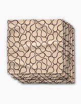 A set of four Gerdadzy Coffee Swirl dinner napkins in beige Geosuede fabric, each with a dark brown abstract line pattern, neatly stacked with slight overlap on a white background.