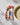 A gold fork rests on a Geometry Cut Paper Leaves Cream recycled dinner napkin, featuring a colorful floral pattern, beside a beige plate on a white textured surface.