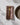 A gold fork rests on Geometry’s Deep Hearth brown and white checkered dinner napkin, folded beside a beige ceramic plate on a white tablecloth with soft shadows.