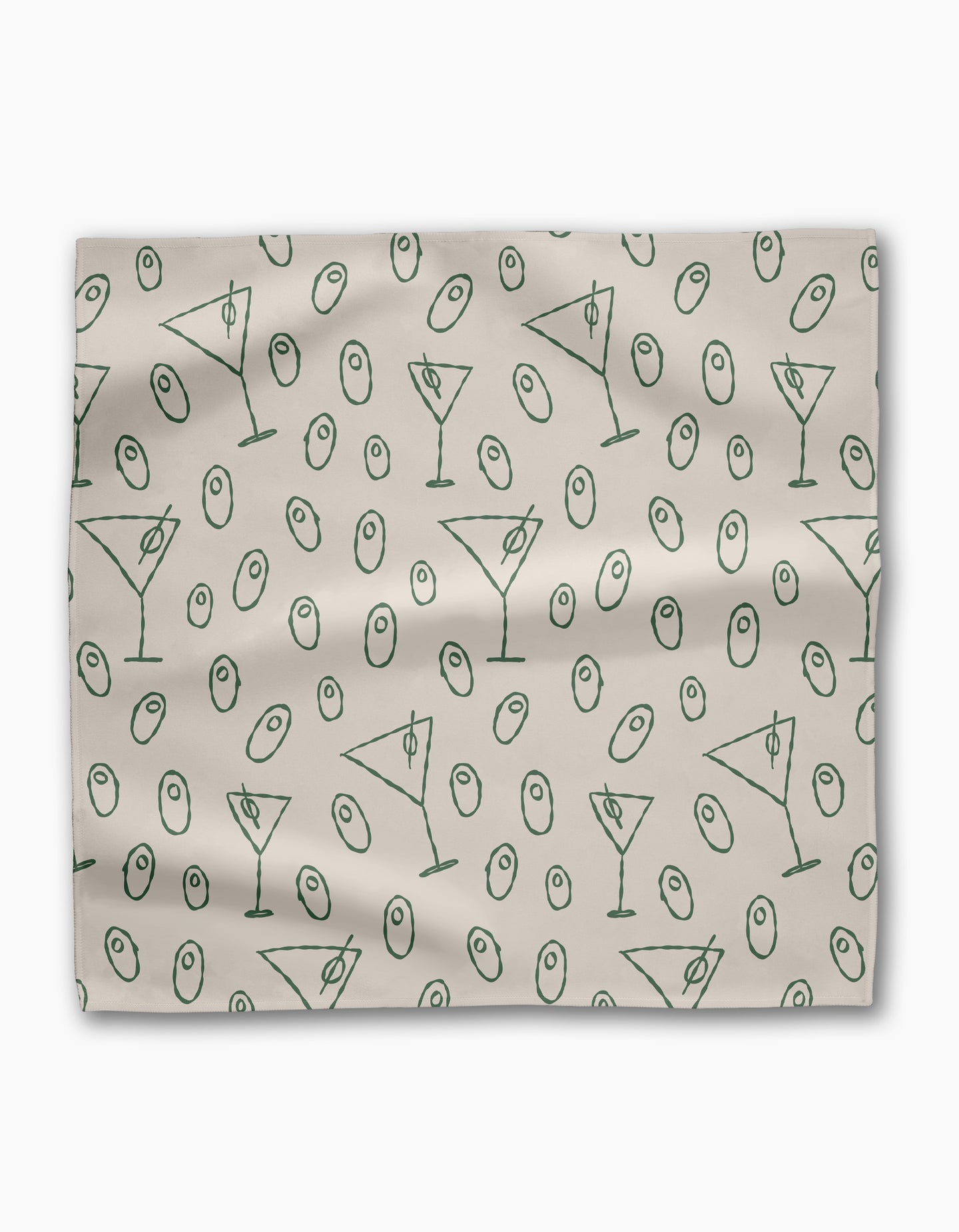 The Dirty Martini dinner napkin set by Rosa Kichline is light beige, made from recycled fabric, and showcases a repeating pattern of green martini glasses and green olives scattered across the surface.