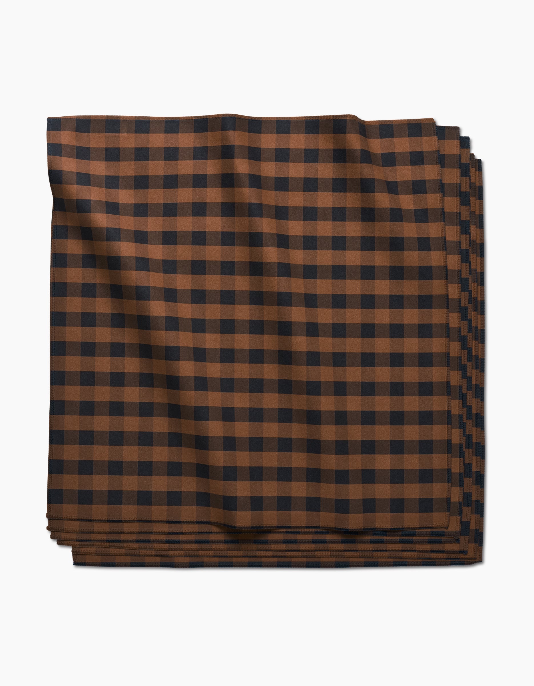 The Fall Gingham Dinner Napkin by GEOMETRY, crafted from Geosuede fabric, features a brown and black checkered pattern and is shown neatly folded against a white background.