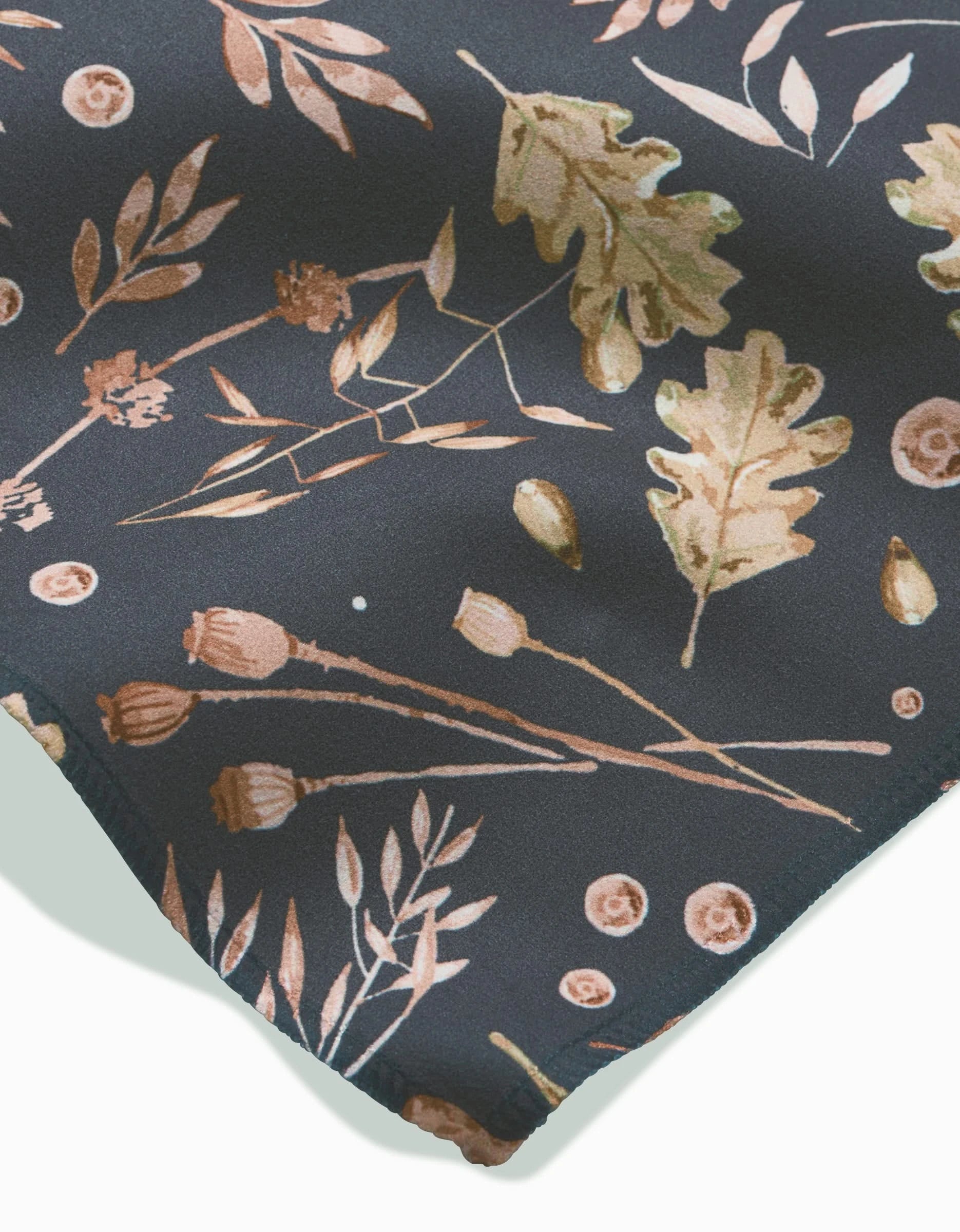A close-up of Fallen Oak by Katie OShea: Geosuede fabric with a botanical print of illustrated oak leaves, seed pods, and small branches in tan, gold, and brown—crafted from post-consumer recycled materials.