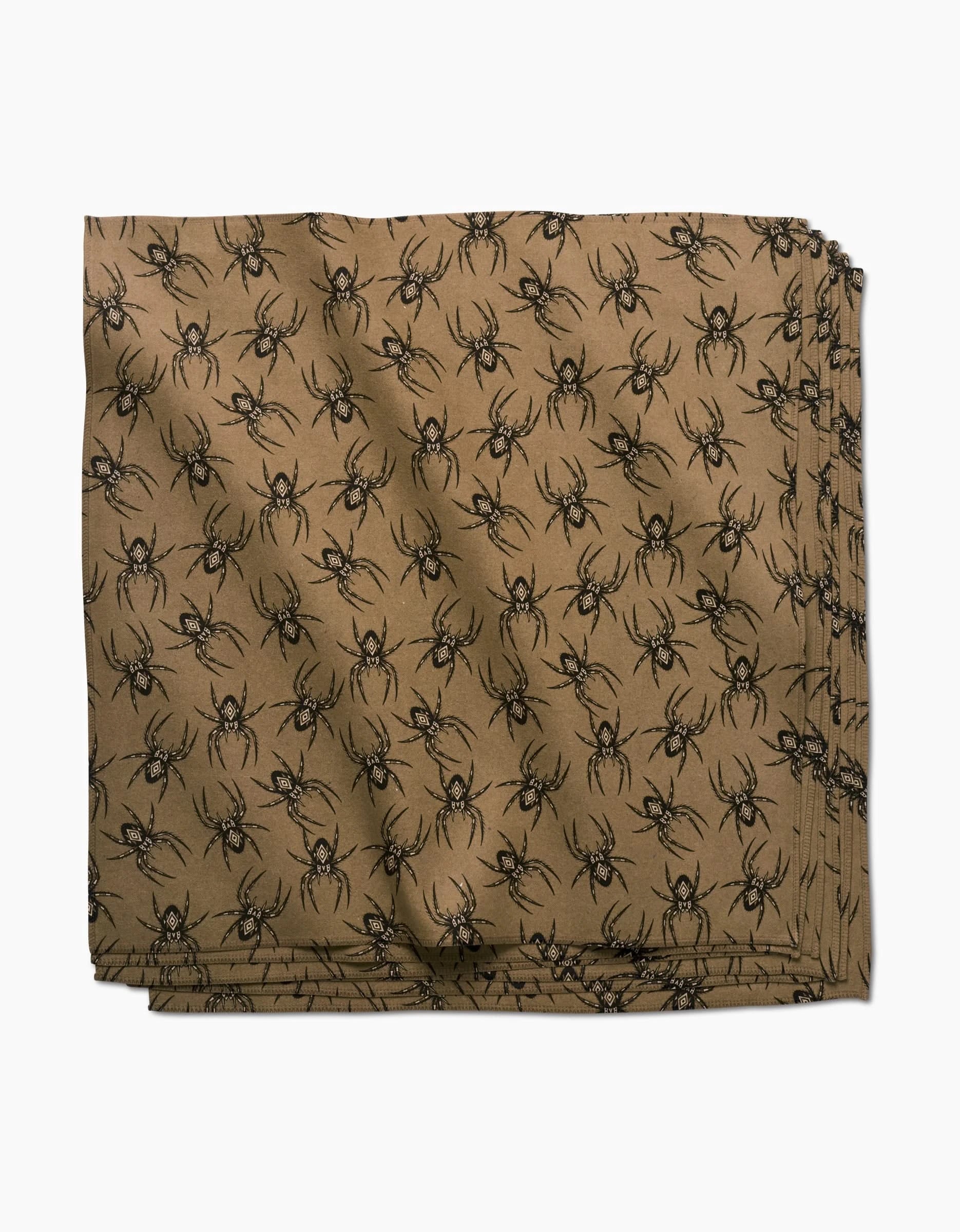A stack of Cole Strem Flash brown dinner napkins made from recycled materials, featuring a repeating black spider pattern, arranged neatly on a white background.